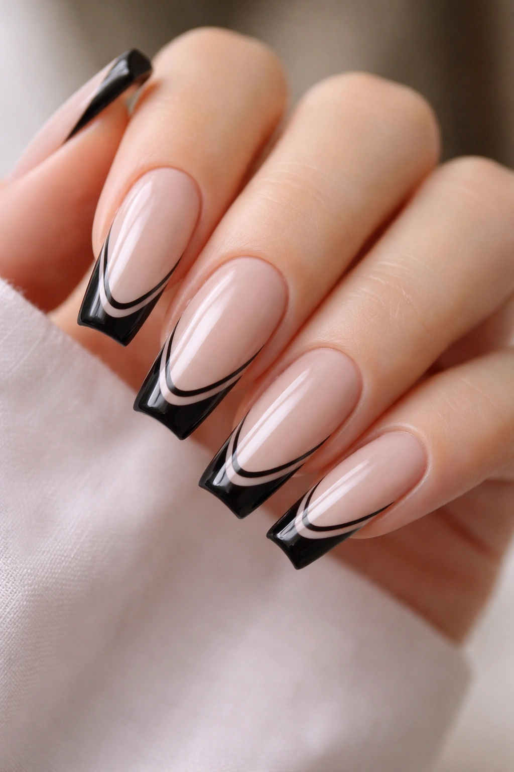 Close-up of double black French tips with a tiny nude gap on milky nude base.