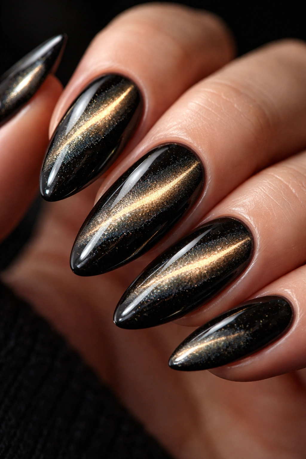Almond nail with two magnetic cat eye shimmer bands on a dark base
