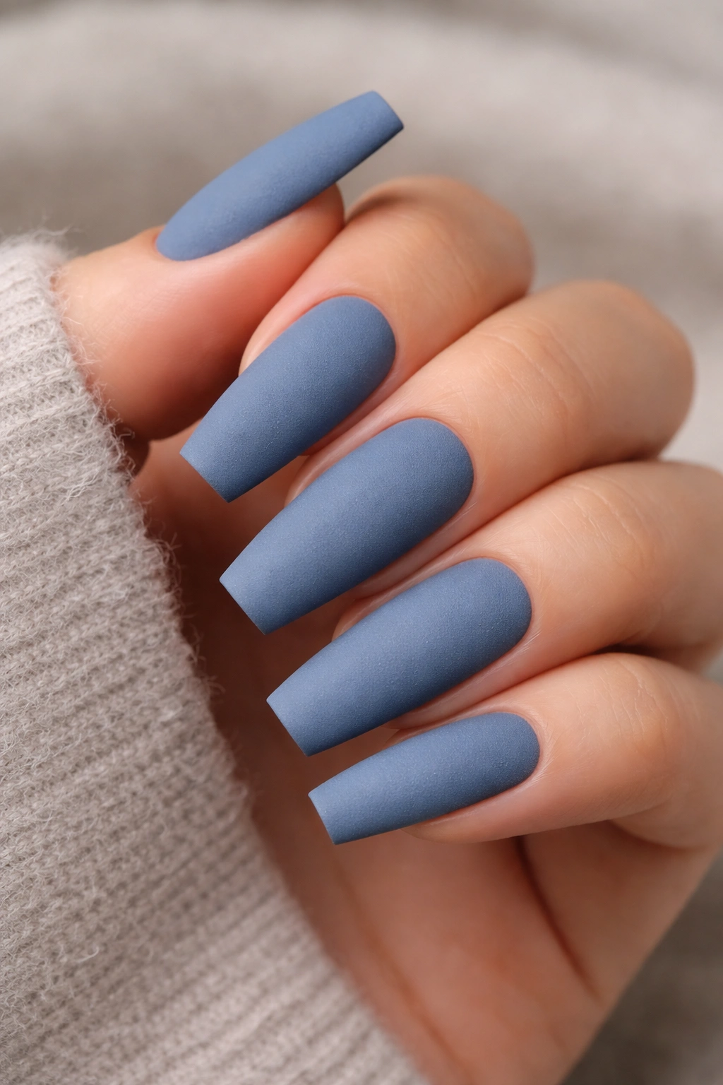 Dusty denim matte coffin nails close-up.