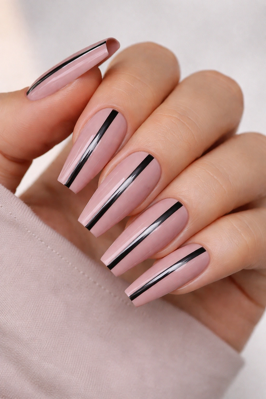 Coffin nails with dusty pink base and a center black chrome stripe