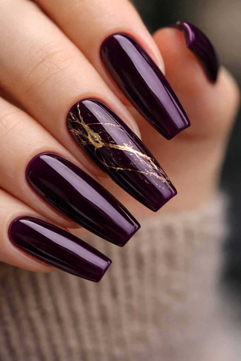 Eggplant purple nails with gold foil veins on a ballerina shape