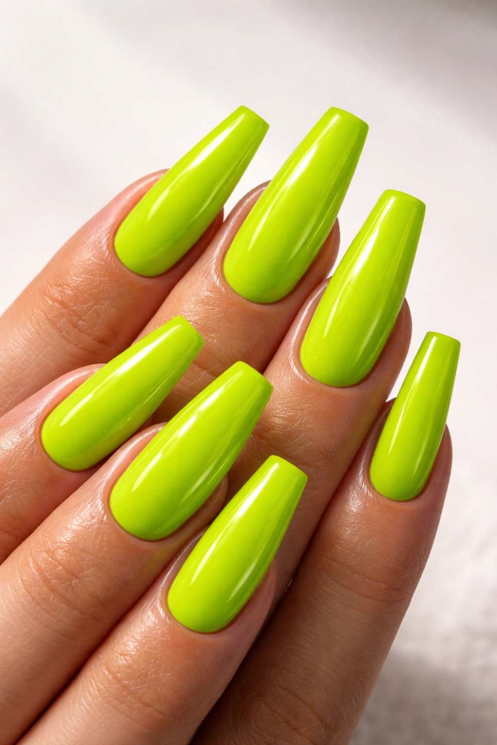 Electric lime coffin nails with wet-look gloss in a medium-long coffin shape