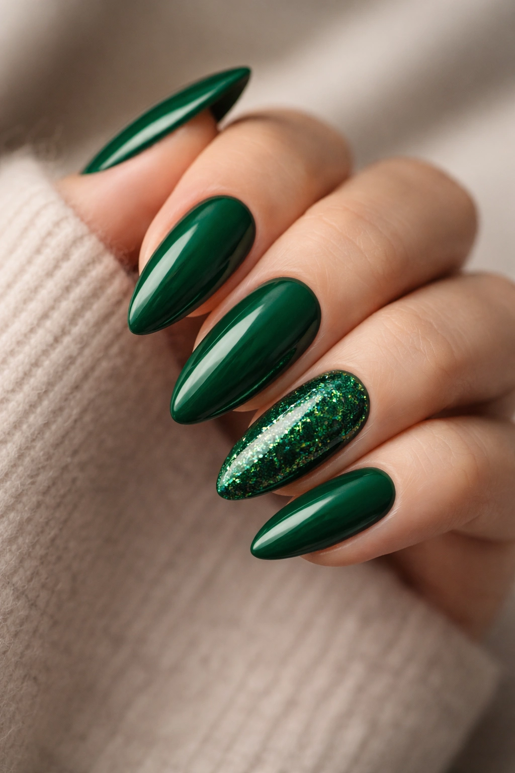 Almond nails with a single emerald glitter accent on a deep green base