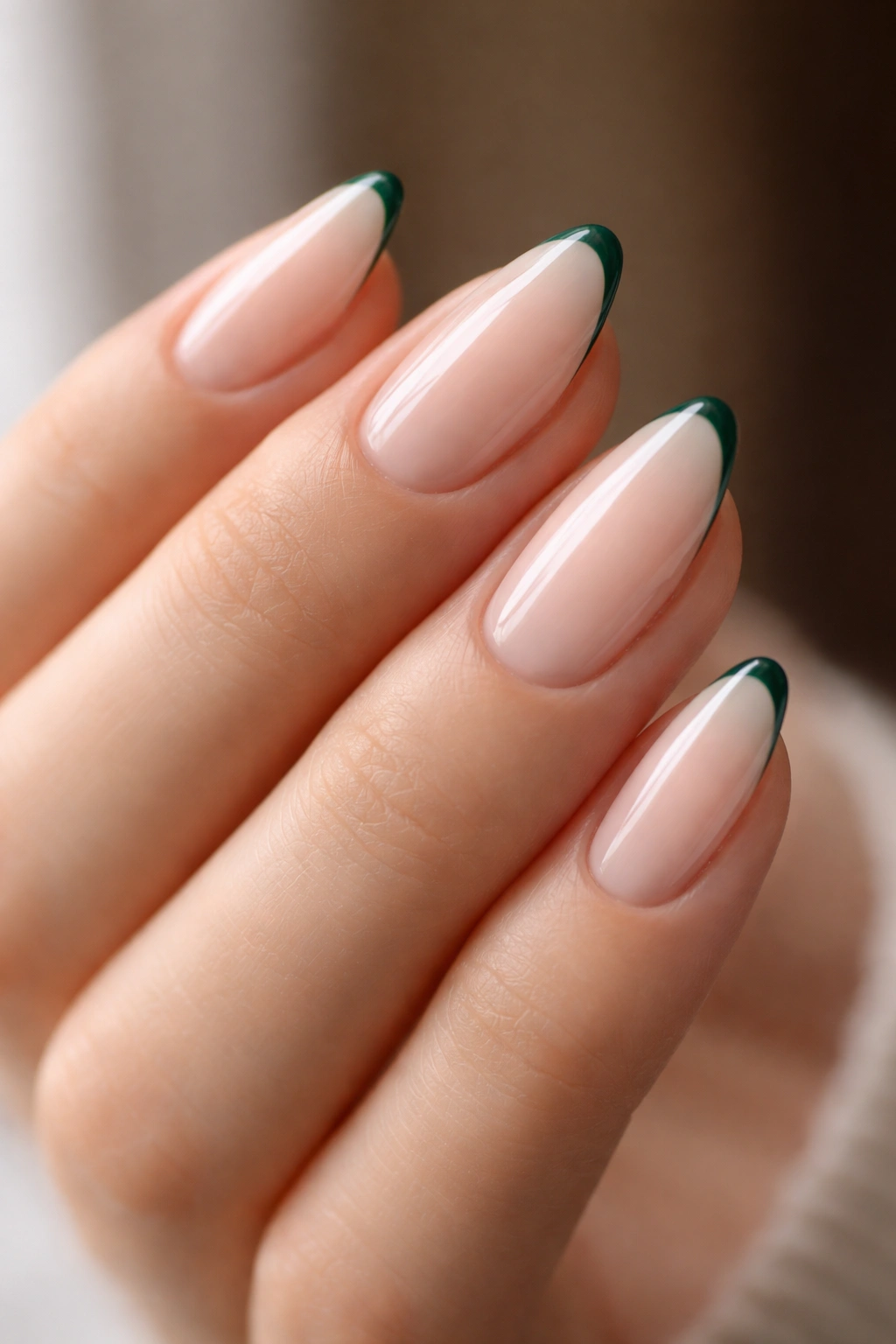 Almond nails with emerald micro French tips on a sheer base