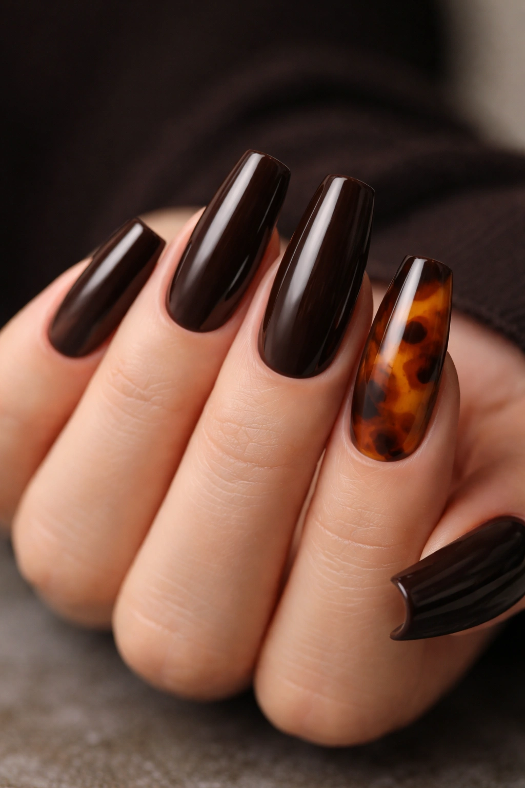 Close-up of espresso brown coffin nails with tortoiseshell accent