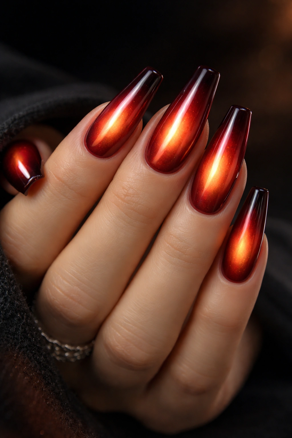 Close-up of fiery aura red chrome coffin nails with center glow