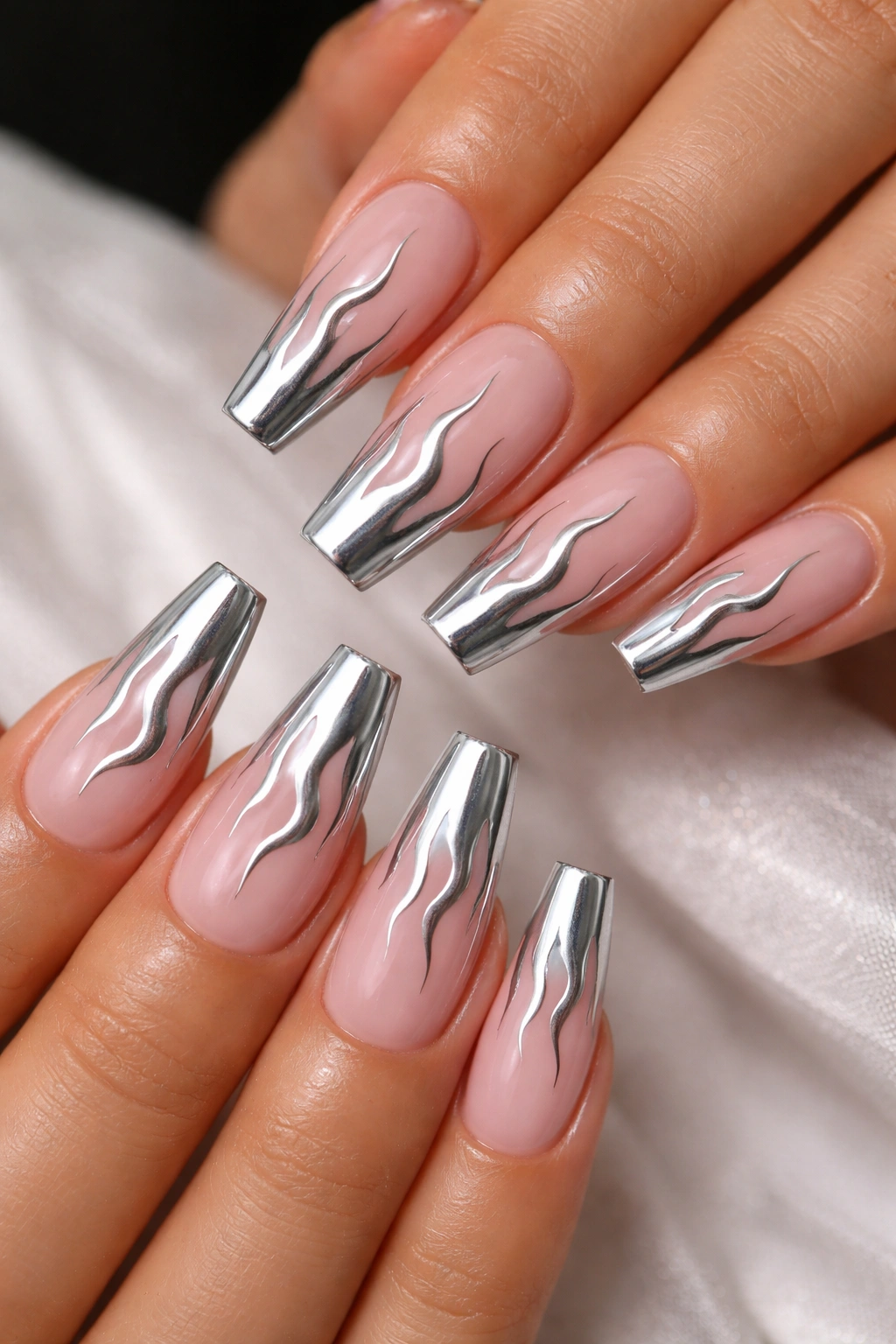 Close-up of sheer pink coffin nails with slim silver chrome flame design