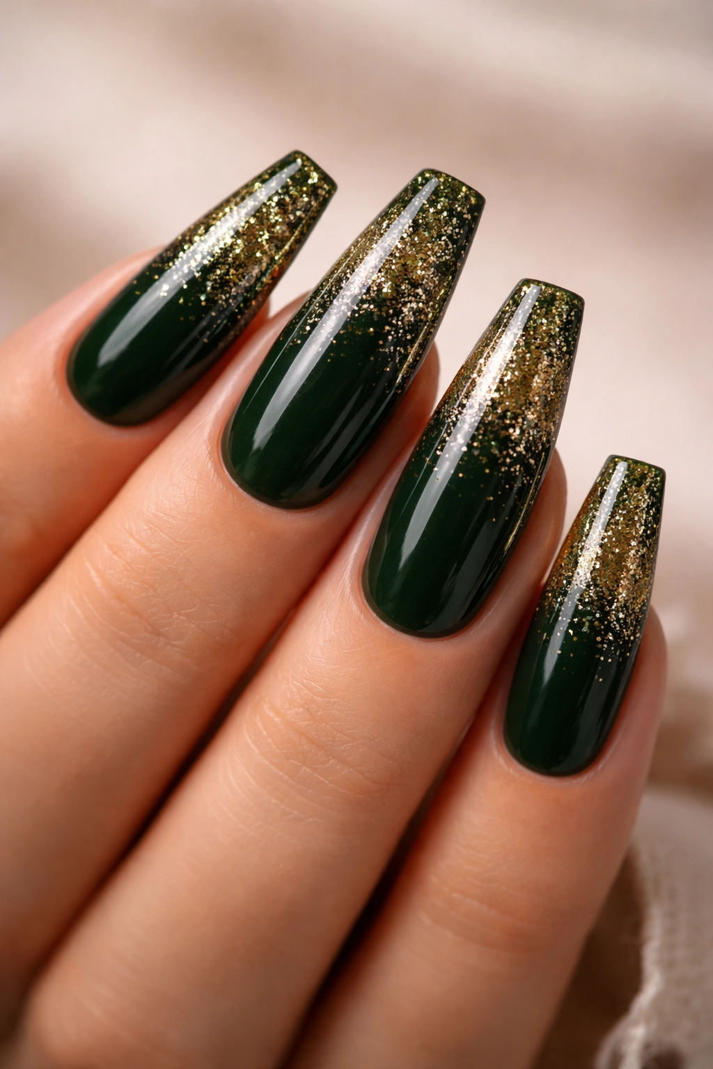 Close-up of coffin nails with forest green base and glitter fade at tips