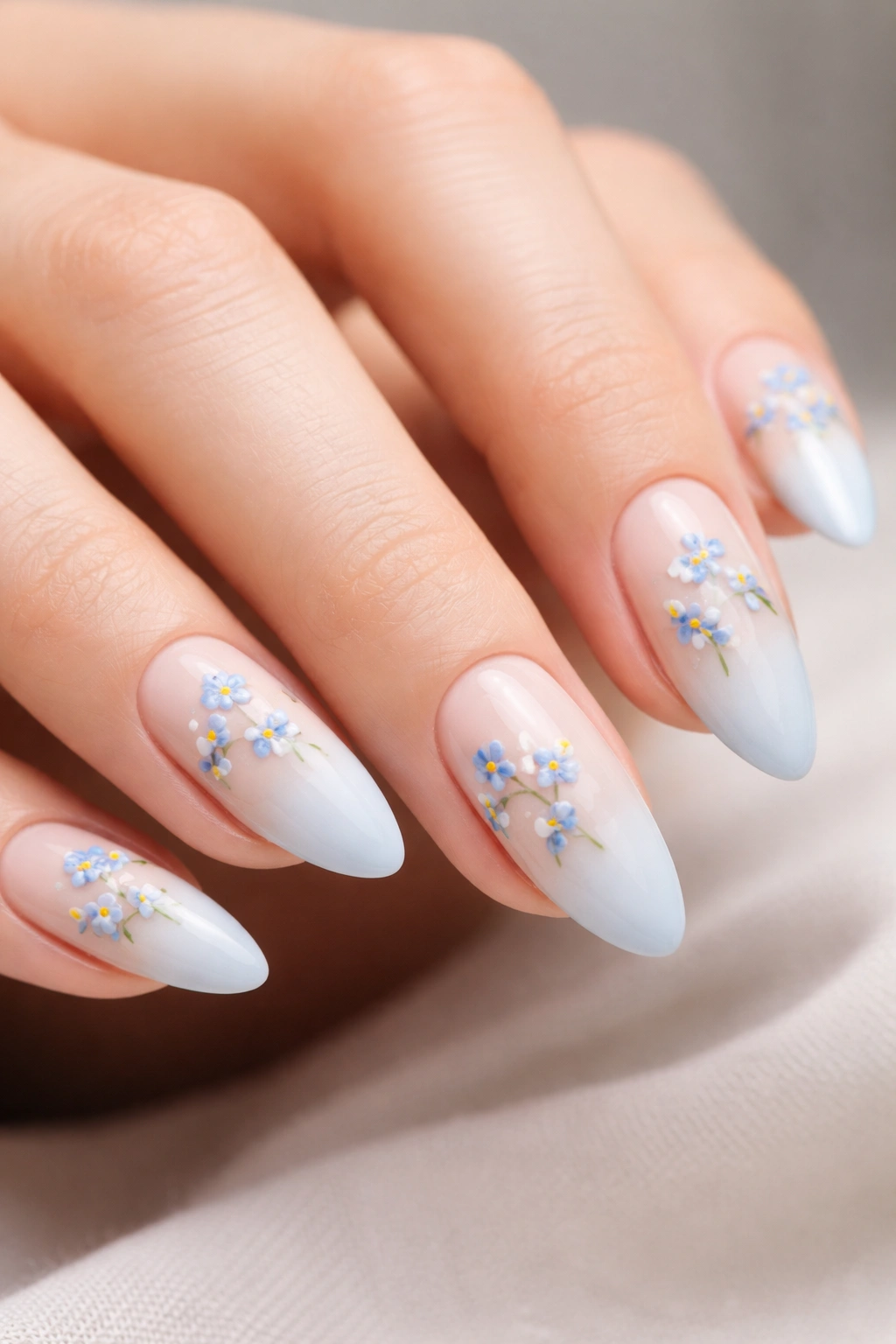 Baby blue almond nails with tiny forget-me-not clusters