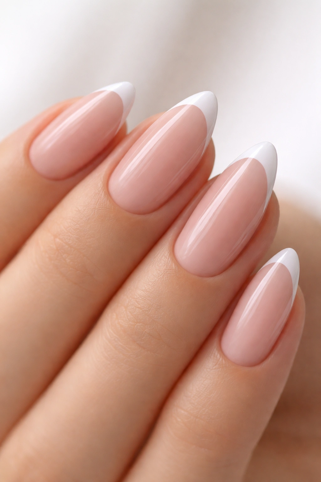Close-up of an almond nail with a skinny white micro French tip on a sheer pink base.