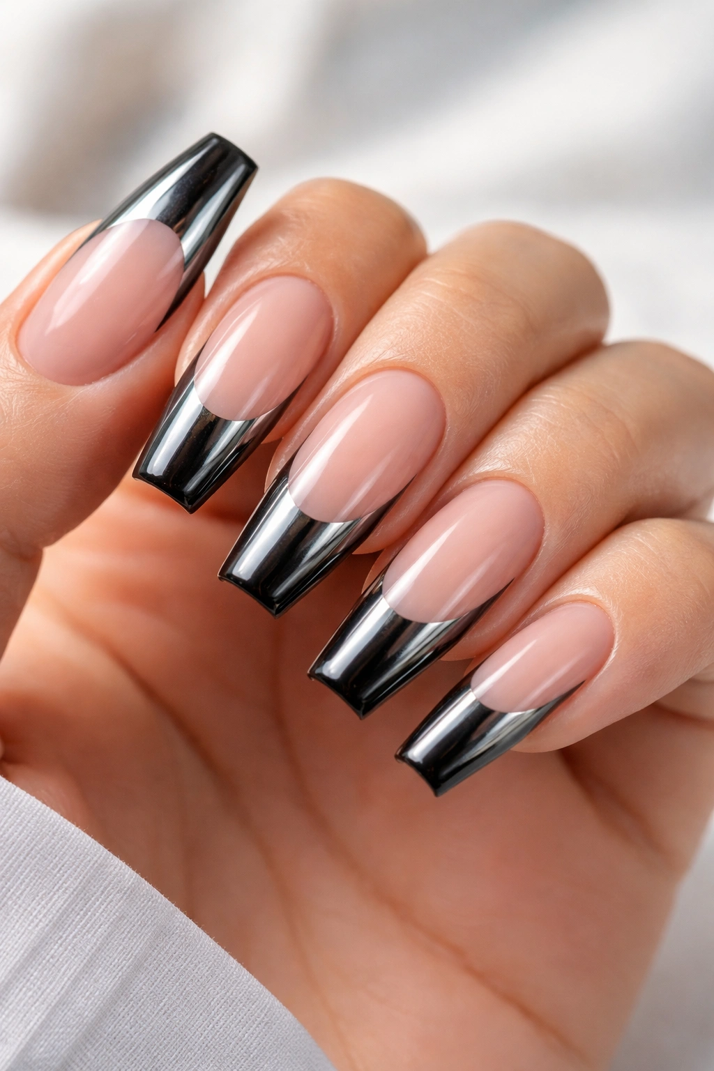 Nude base coffin nails with black chrome French tips on medium-length nails
