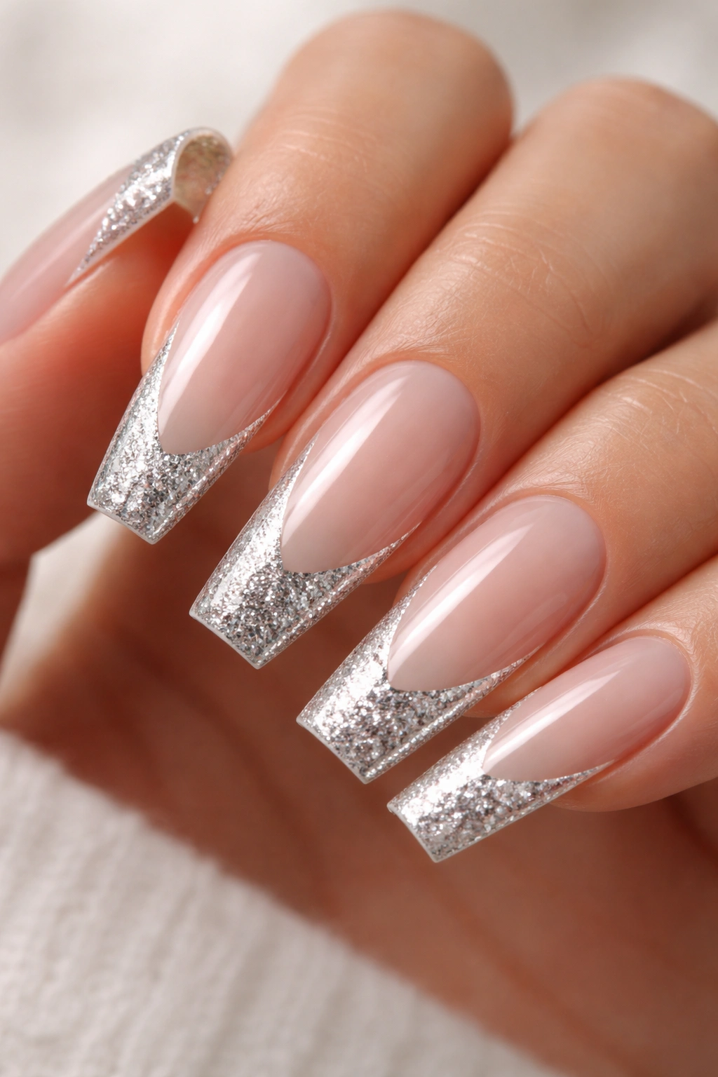 Nails with silver glitter French tips on milky pink base