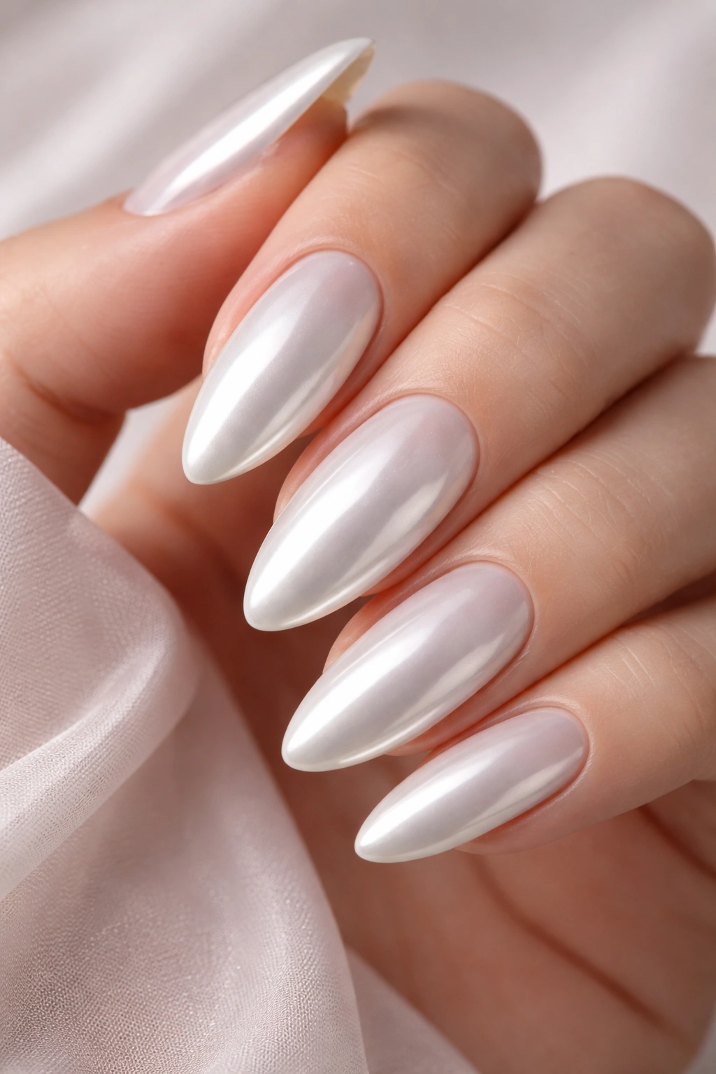 Almond nails with full-coverage glazed pearl chrome on ivory base