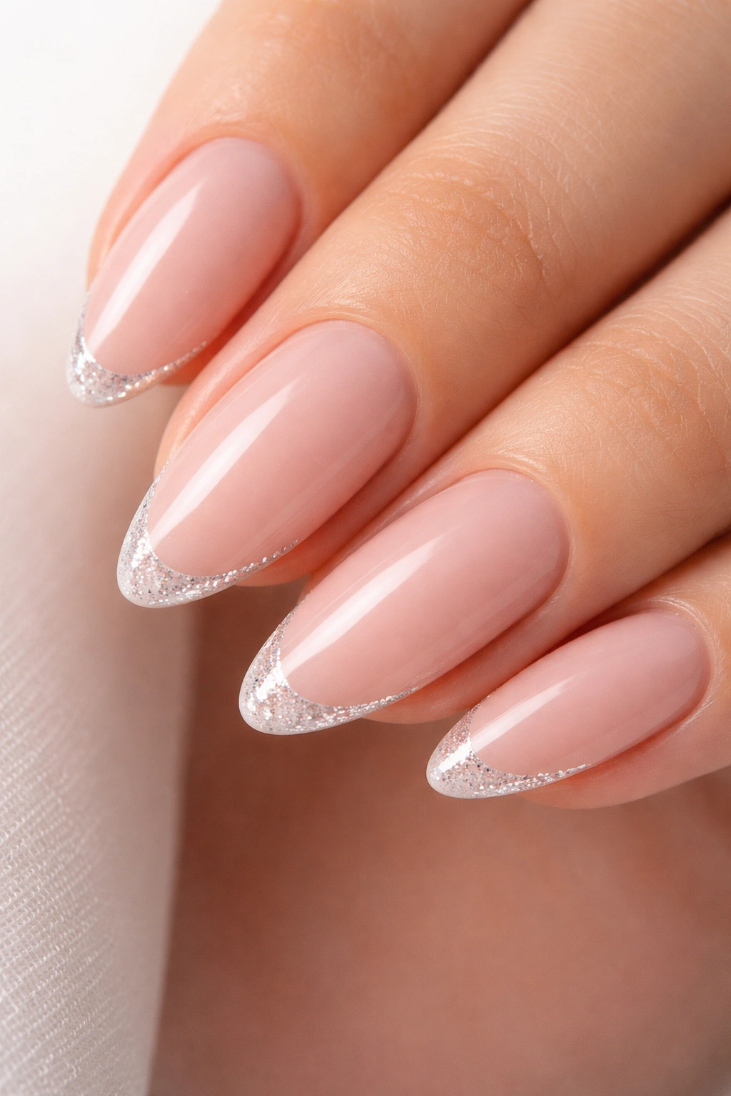Almond nail with a thin glitter line at the tip on a nude base