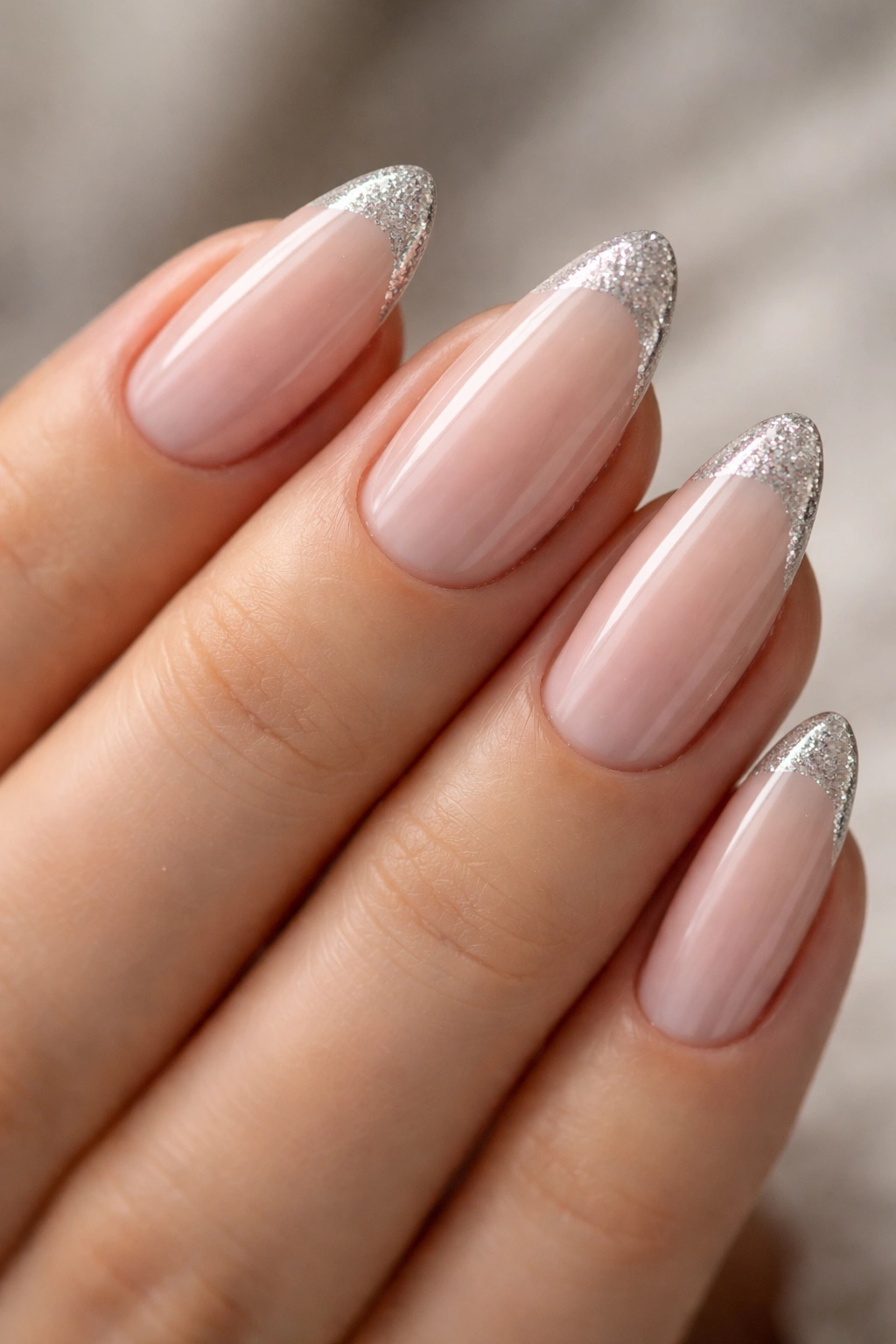 Almond nails with a narrow silver glitter tip on nude base