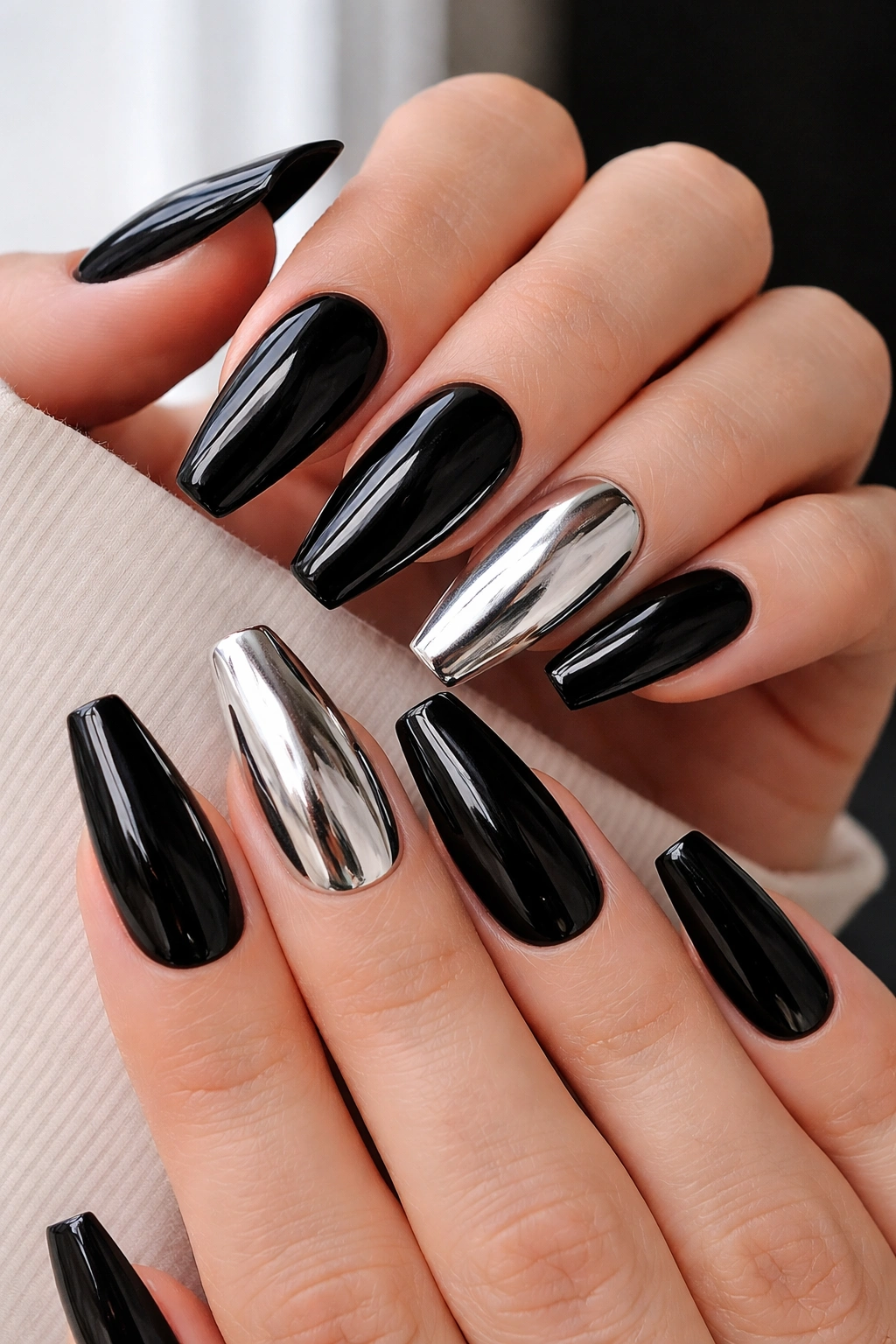 Glossy black coffin nails with two mirror silver accents on a hand