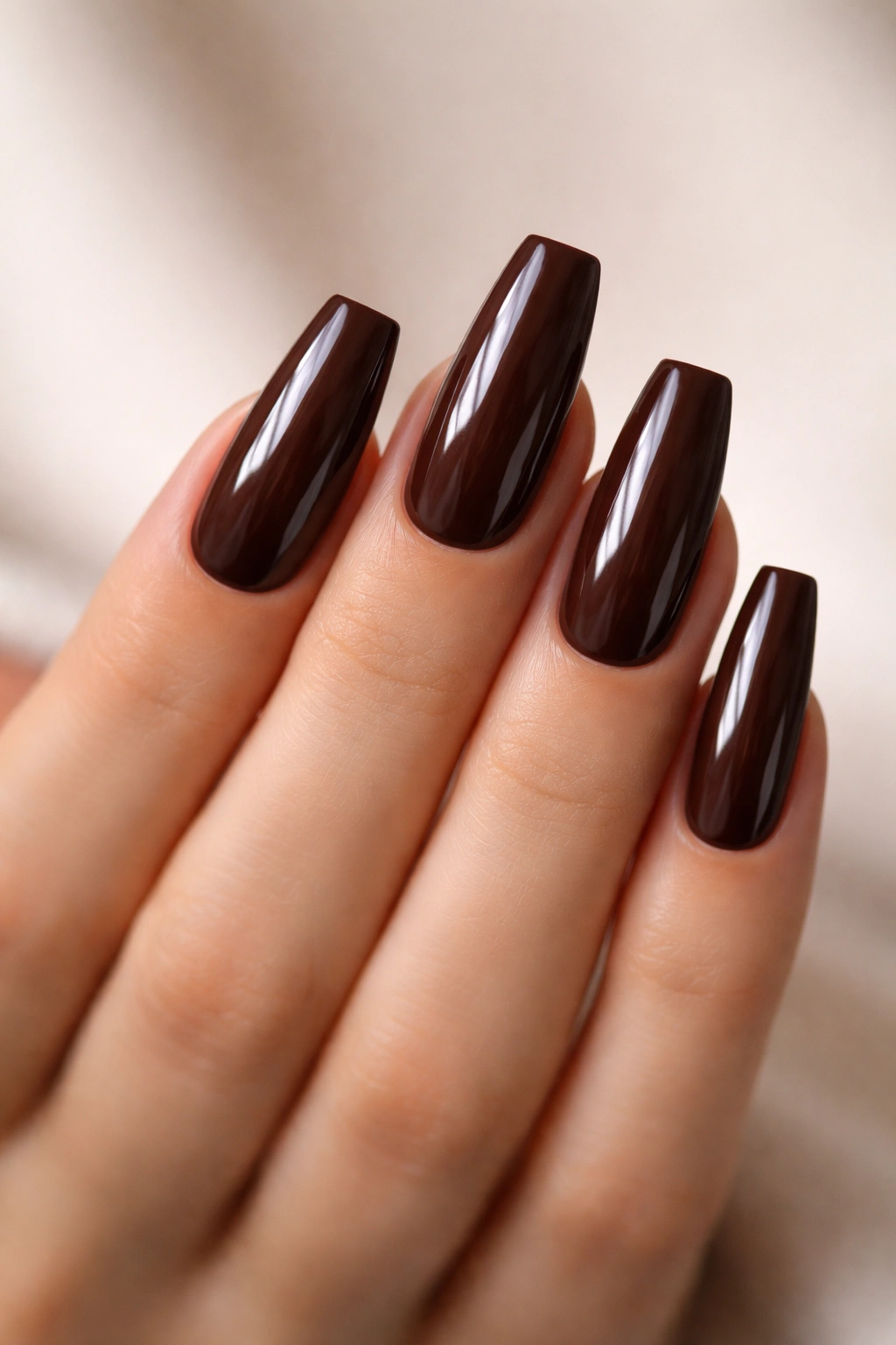 Close-up of glossy chocolate brown coffin nails