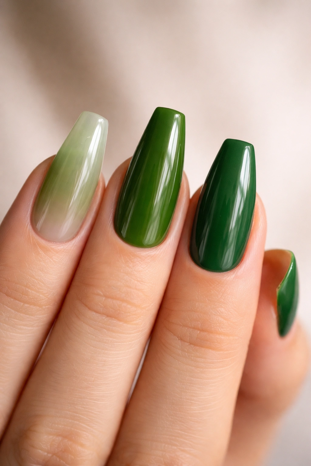 Close-up of three coffin nails in green showing gel overlay, acrylic extension, and press-on base