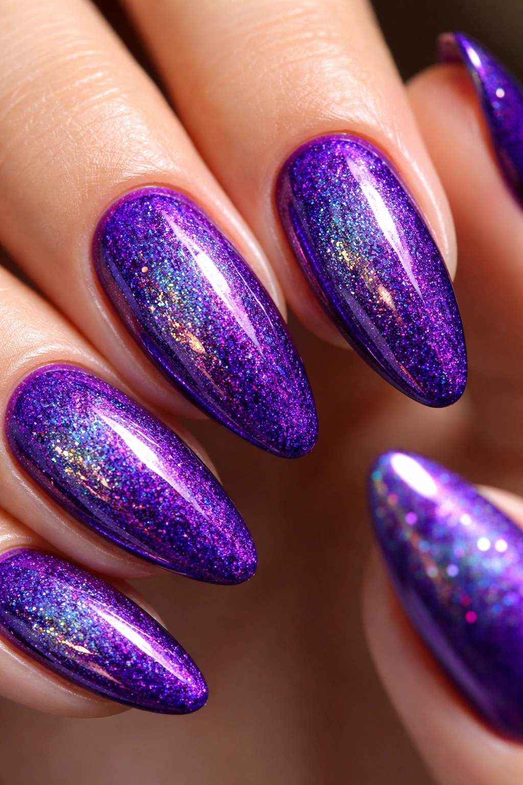Close-up of almond nails with holographic violet sparkle on a violet base