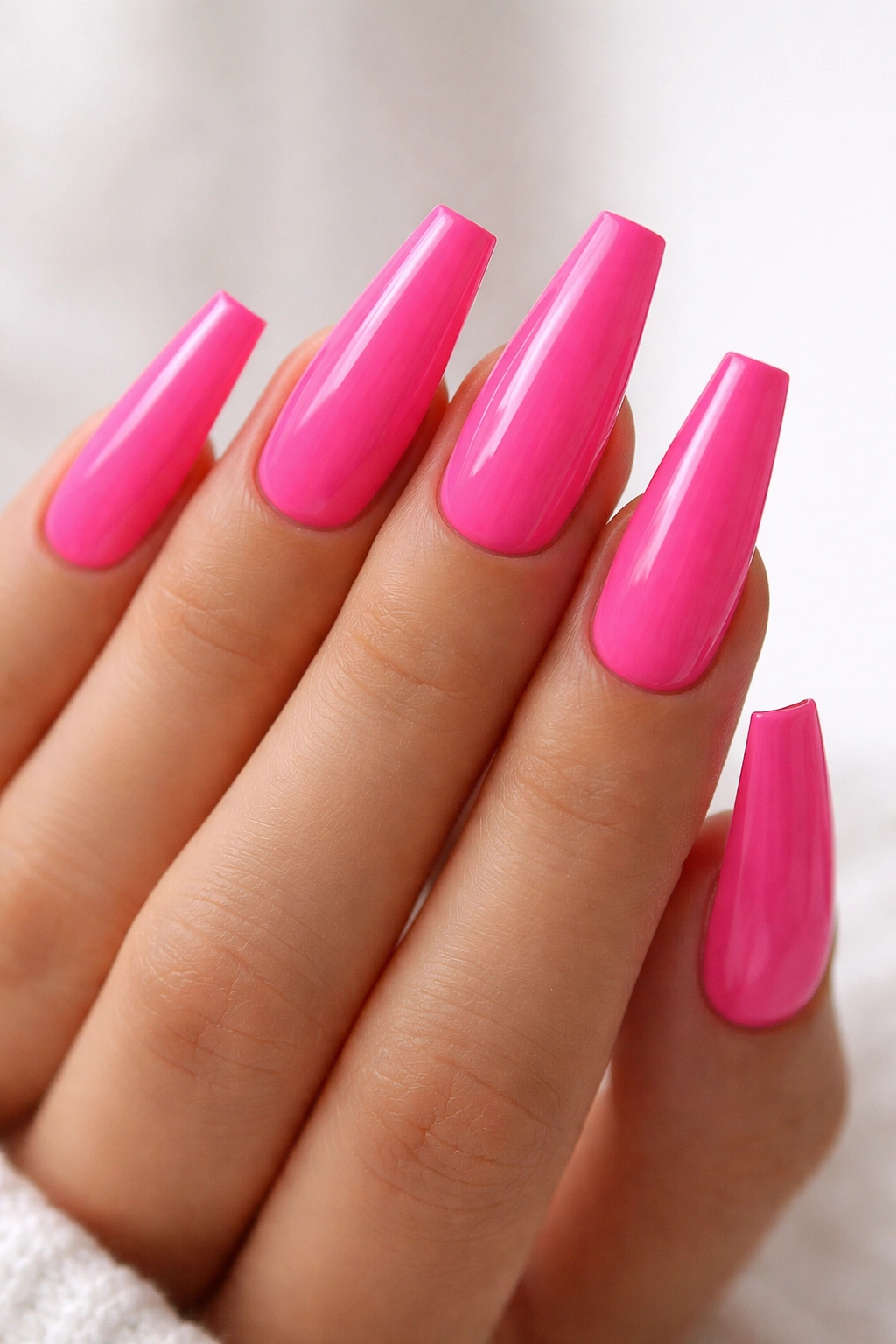 Hot pink coffin nails with razor-clean tips and glossy finish