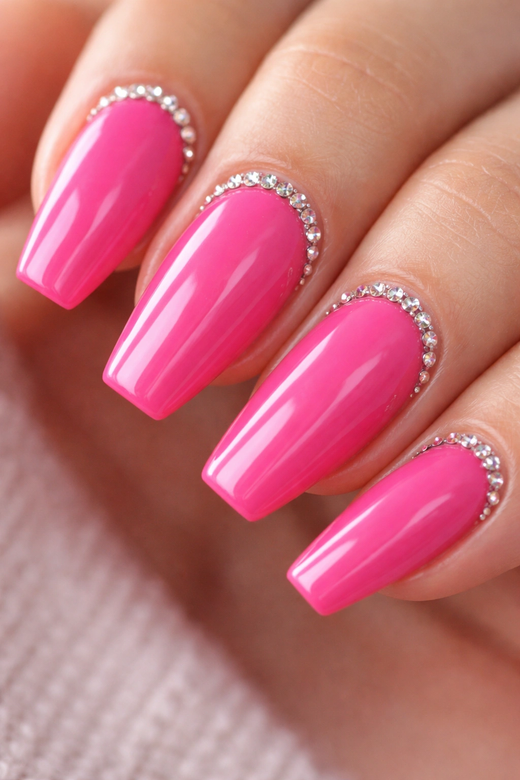 Coffin nails with small rhinestone frames near cuticles on a pink base