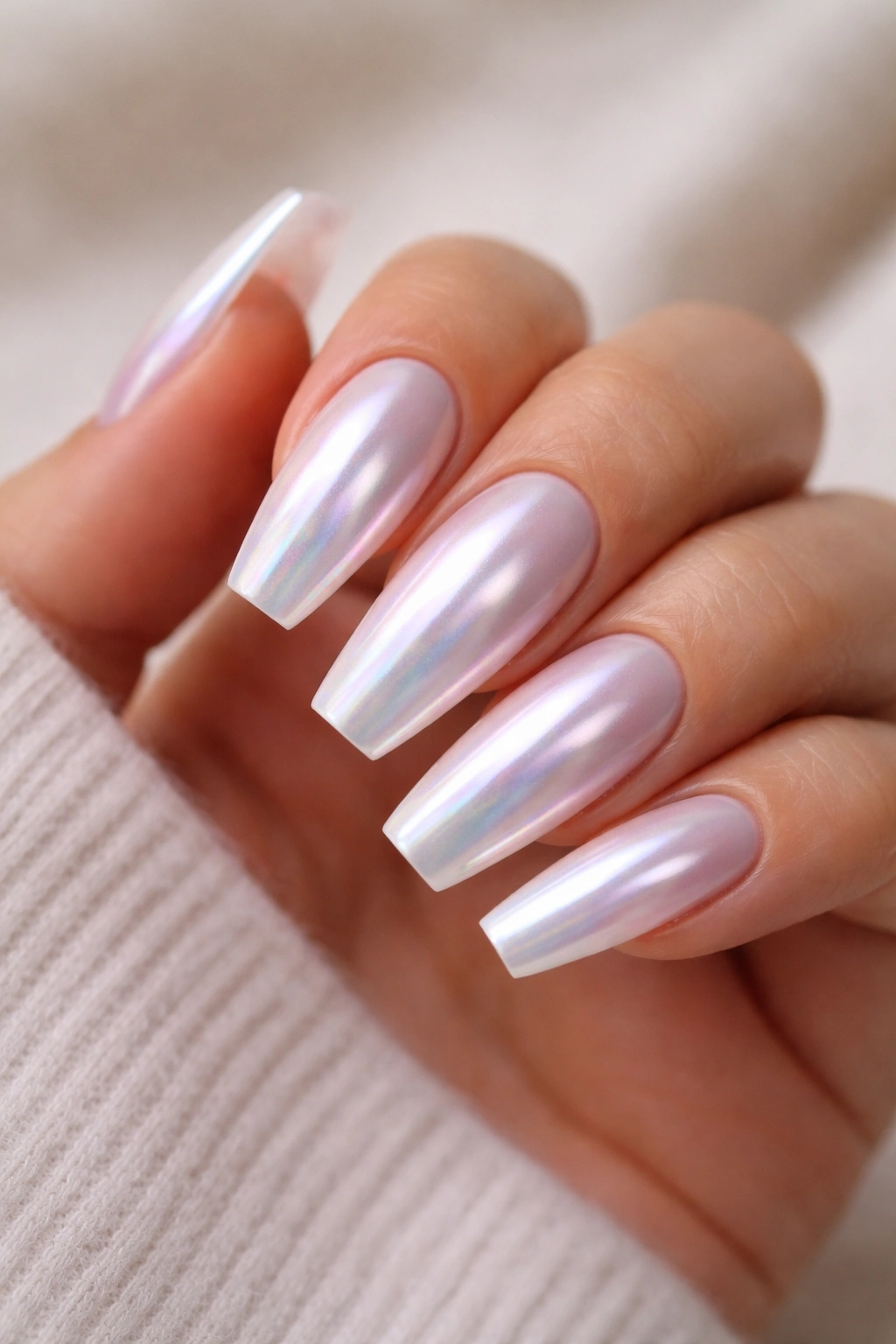 Close-up of iridescent glazed pearl coffin nails with milky base and chrome top