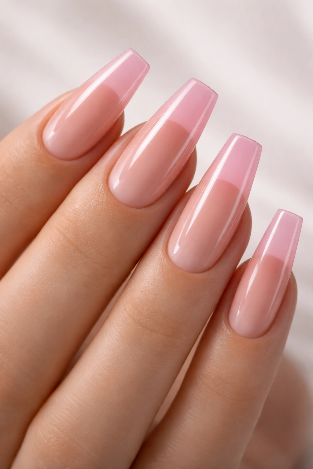 Close-up of jelly pink coffin nails with glossy translucent tips