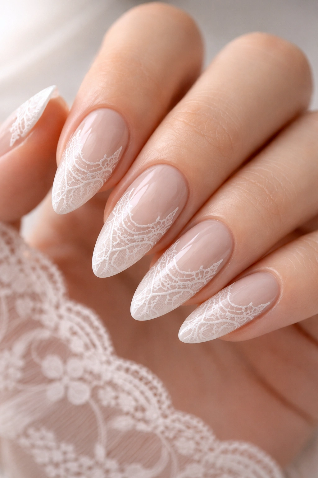 Close-up of lace-inspired white almond nails with delicate line work