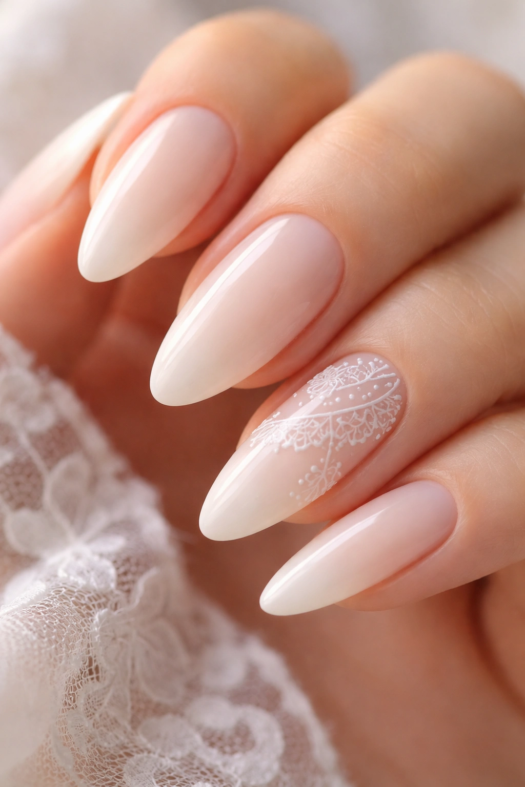 Almond nails with delicate lace-inspired white linework on a milky base