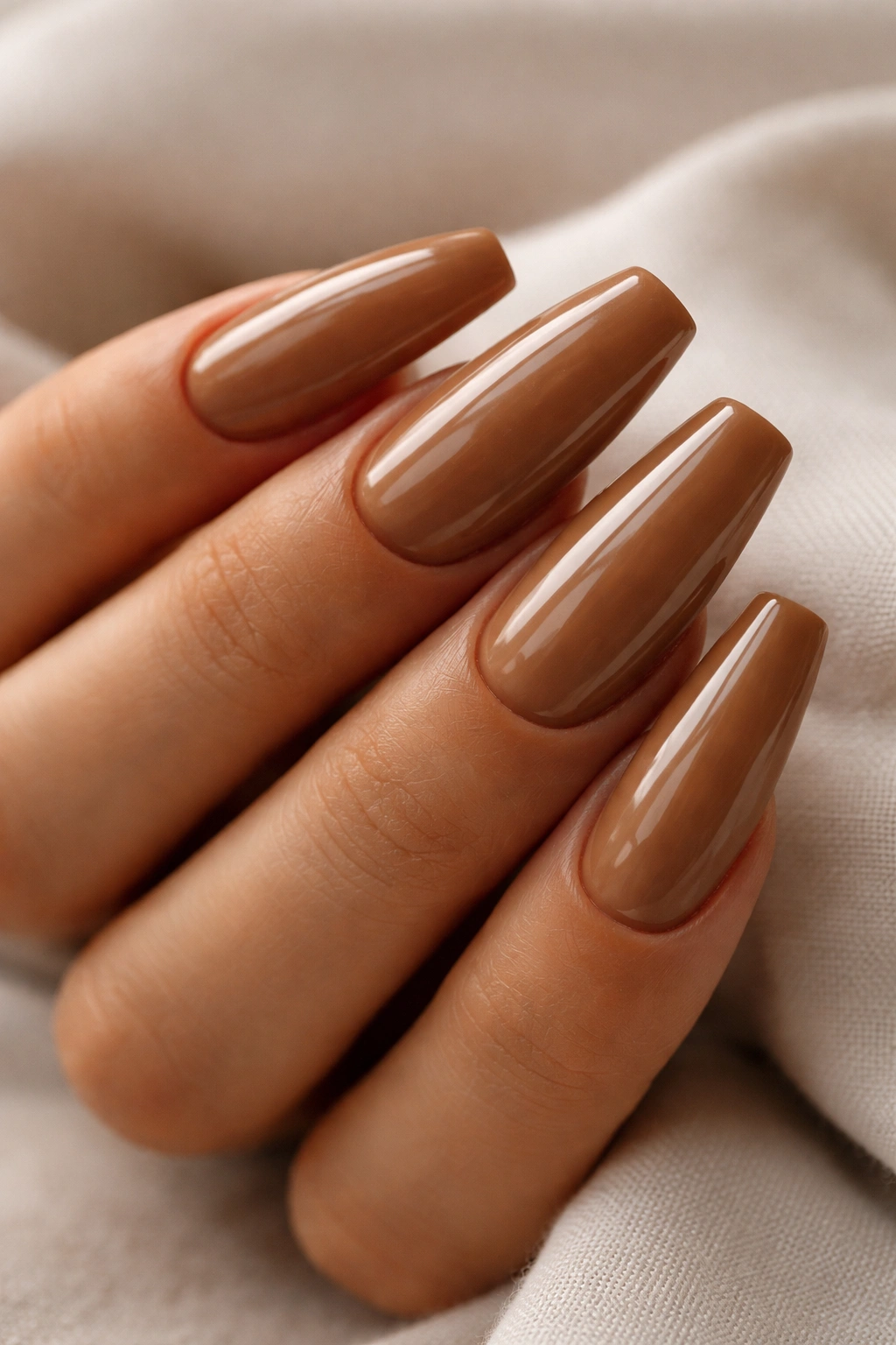 Close-up of latte brown coffin nails on a hand