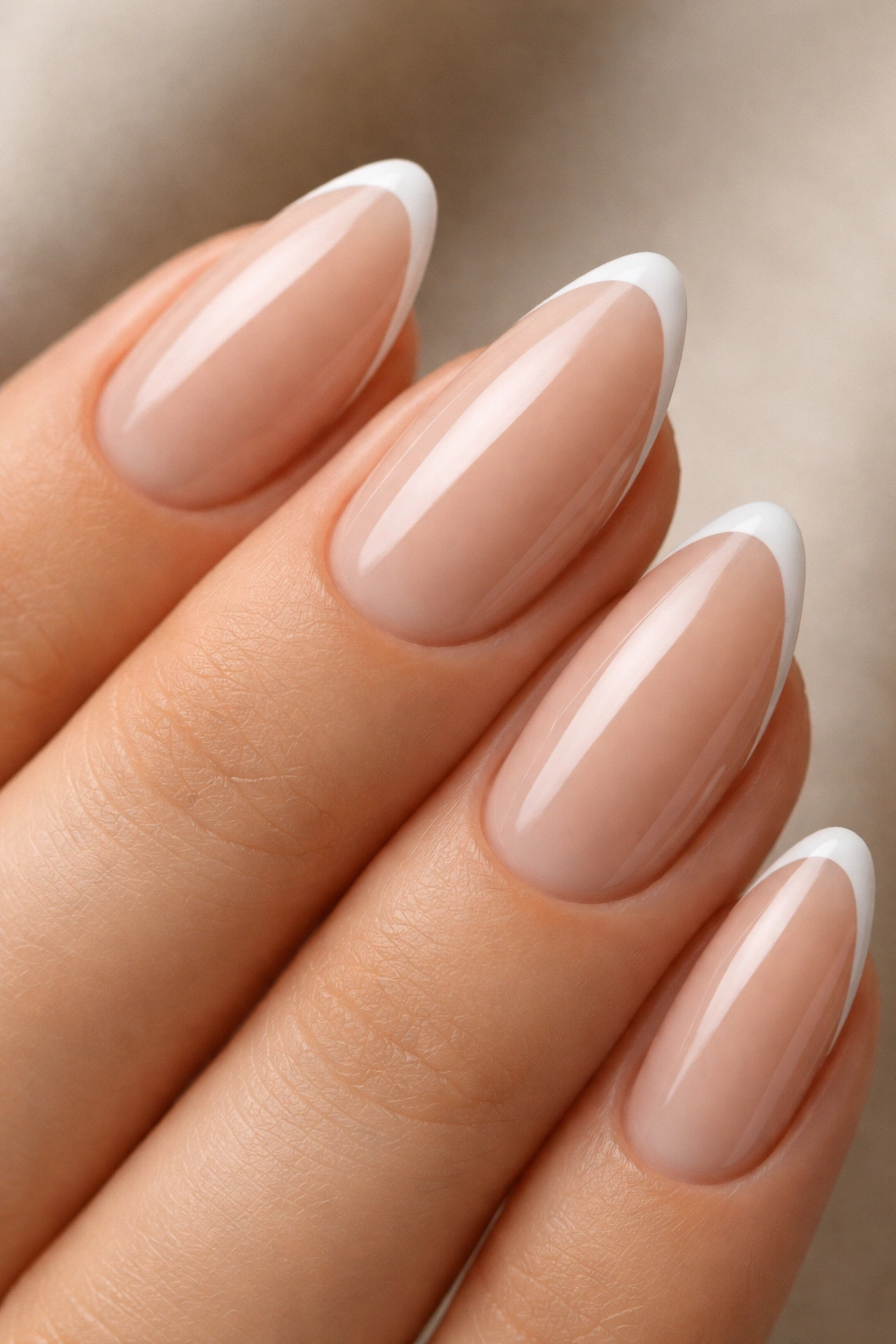 Latte nude almond nails with thin white micro-French tip; close-up