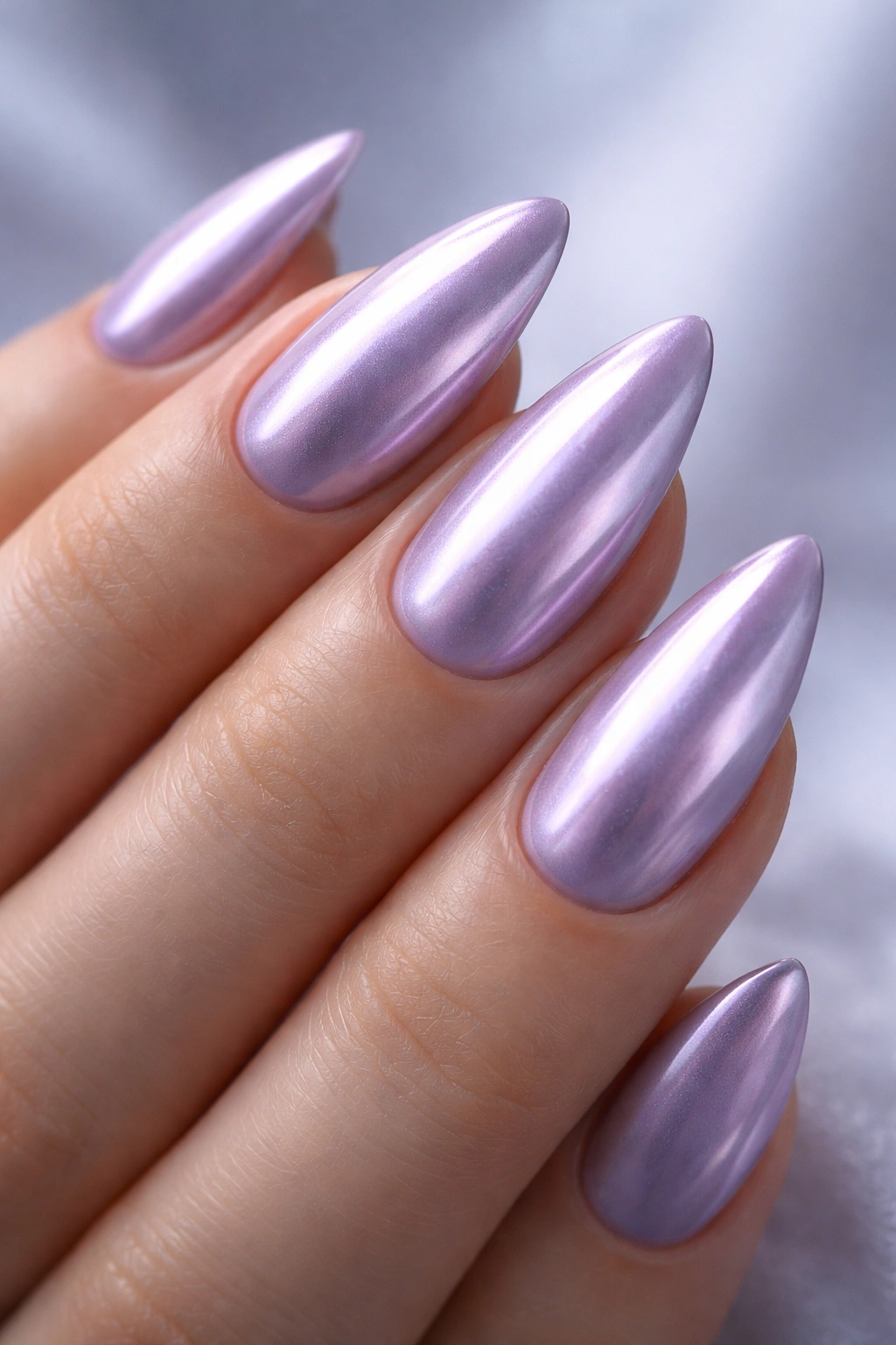 Close-up lavender chrome almond nails with lilac base and pearly chrome overlay