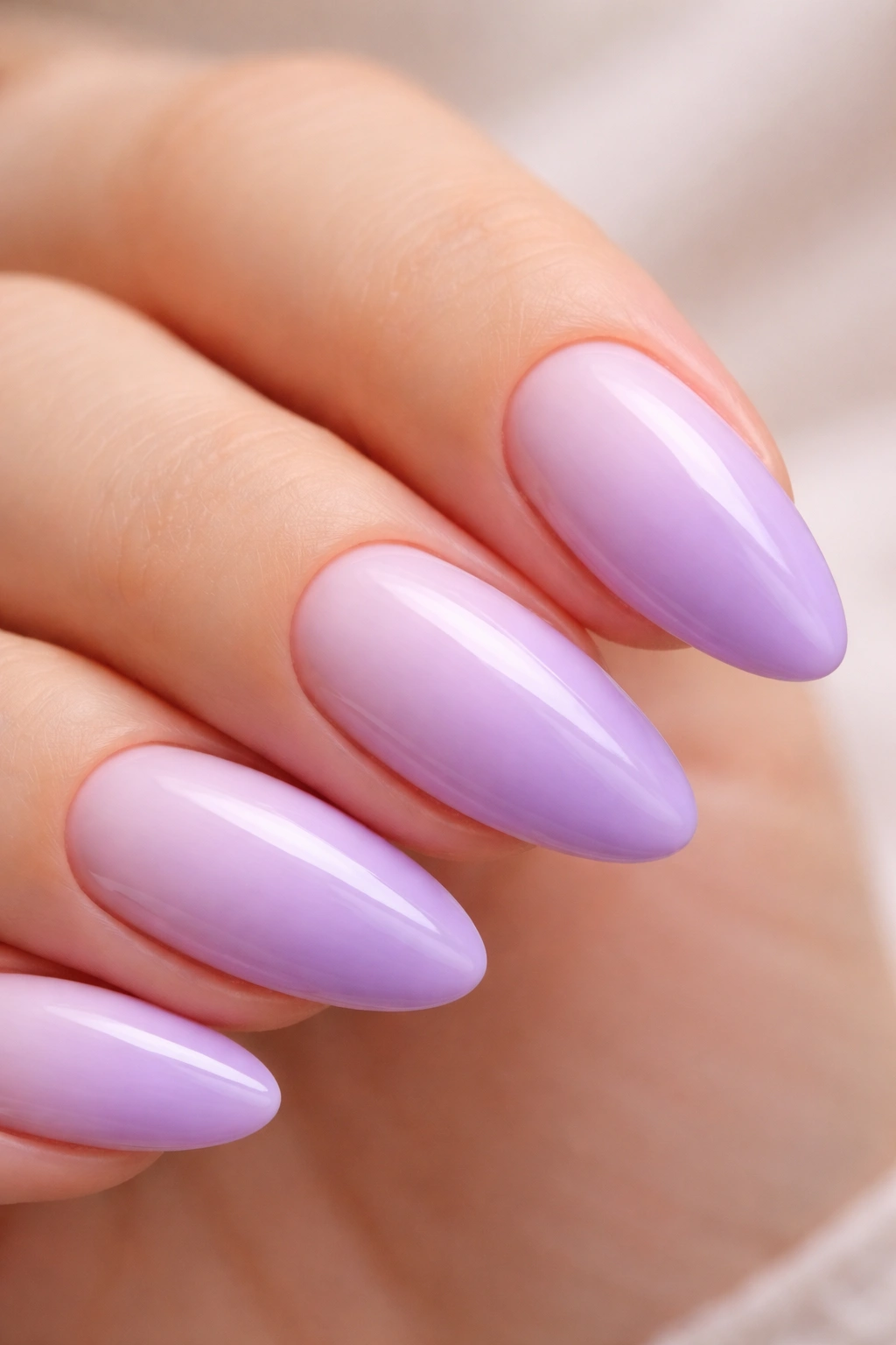 Close-up lavender to lilac cloud fade almond nails with soft gradient