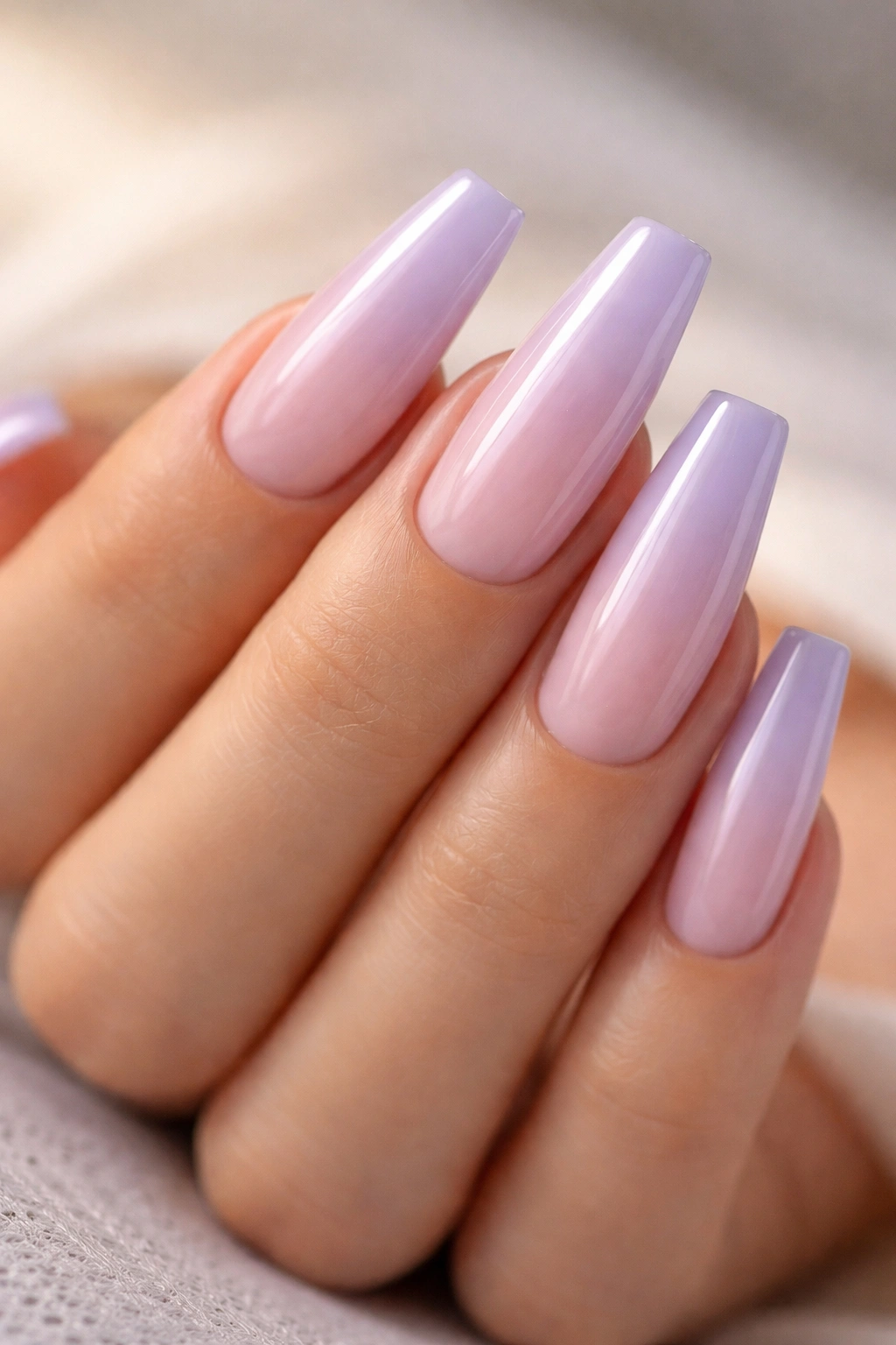 Hand with lavender milk coffin nails featuring sheer pink base and lavender overlay