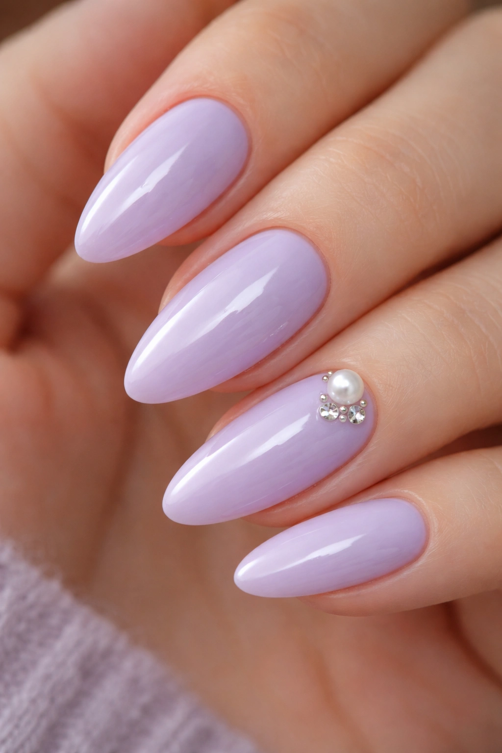 Almond nails with a pearl and tiny crystals on lavender polish