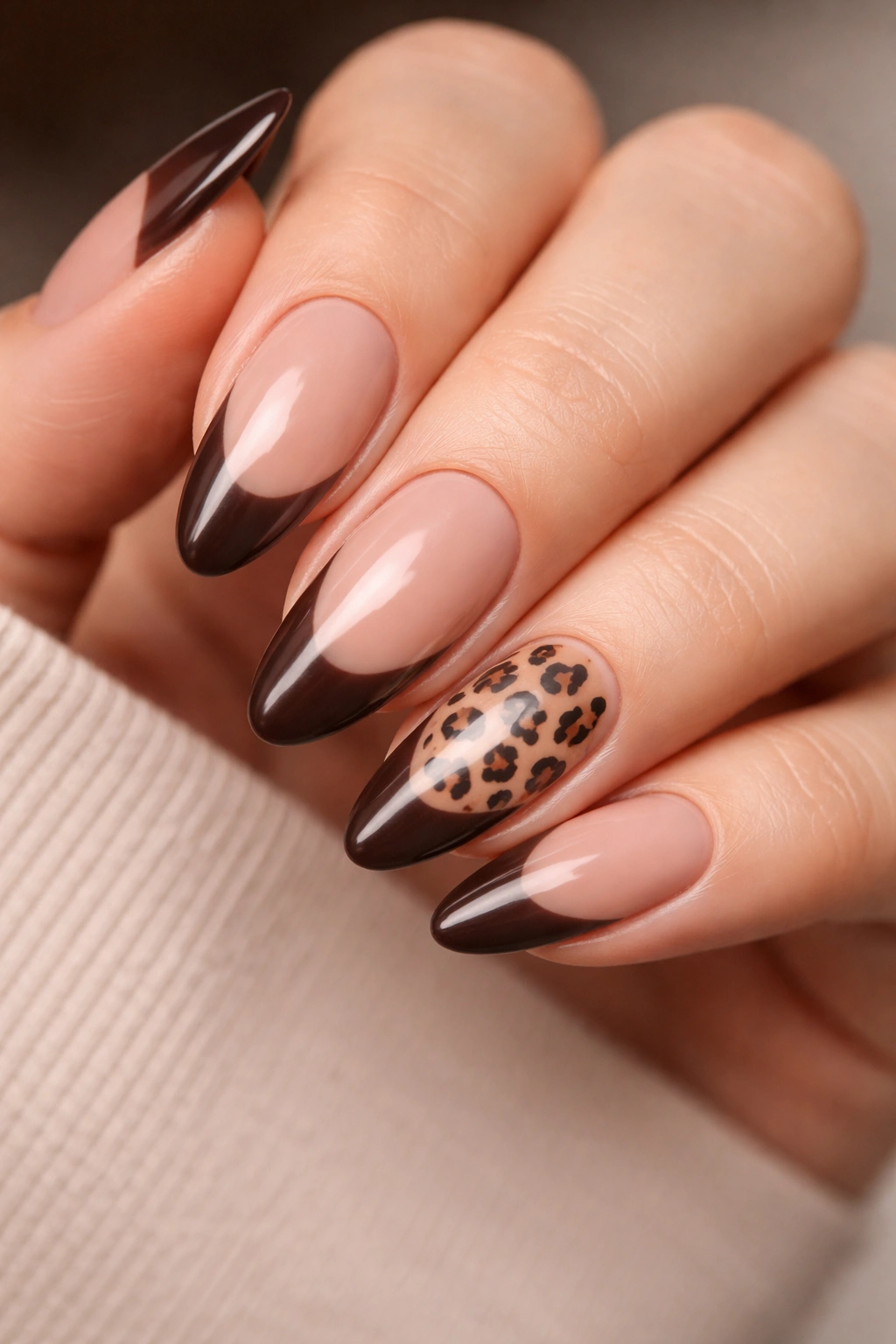 Almond nails with chocolate French tips and small leopard accents, glossy finish