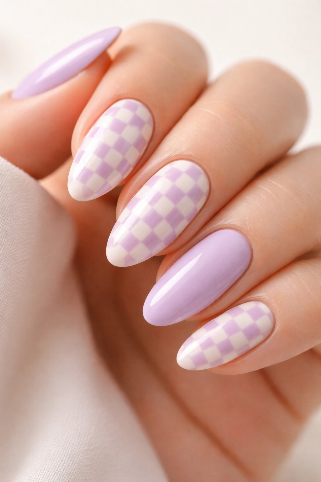 Close-up of almond nails with retro lilac checkered pattern on cream base