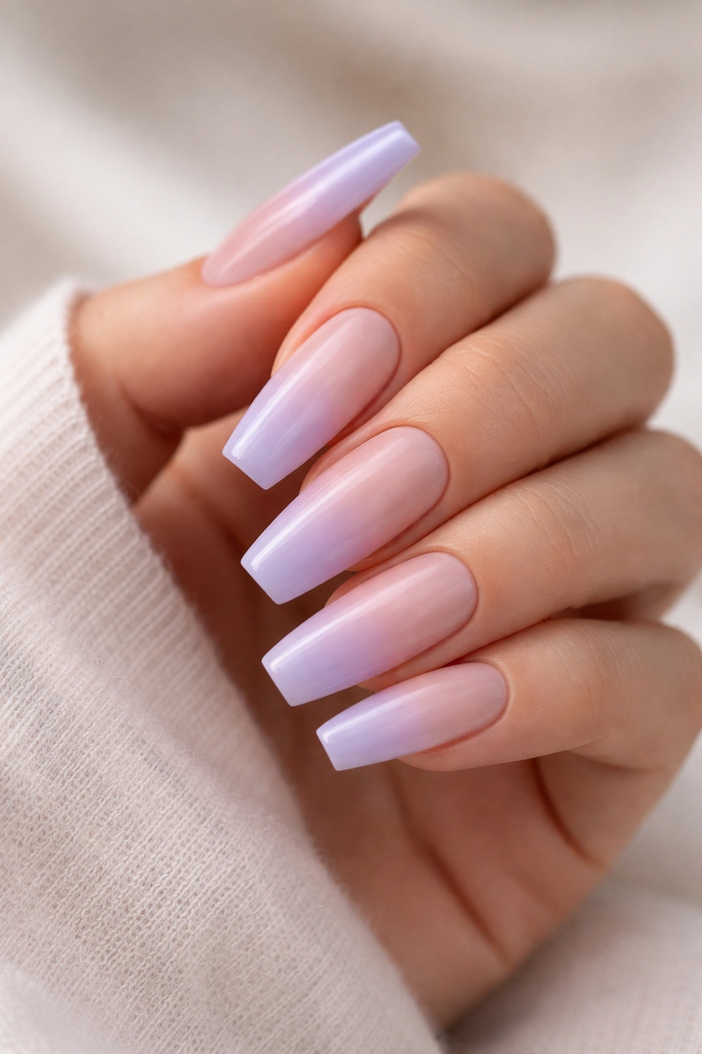 Close-up of lilac French fade coffin nails with a soft diffused tip.