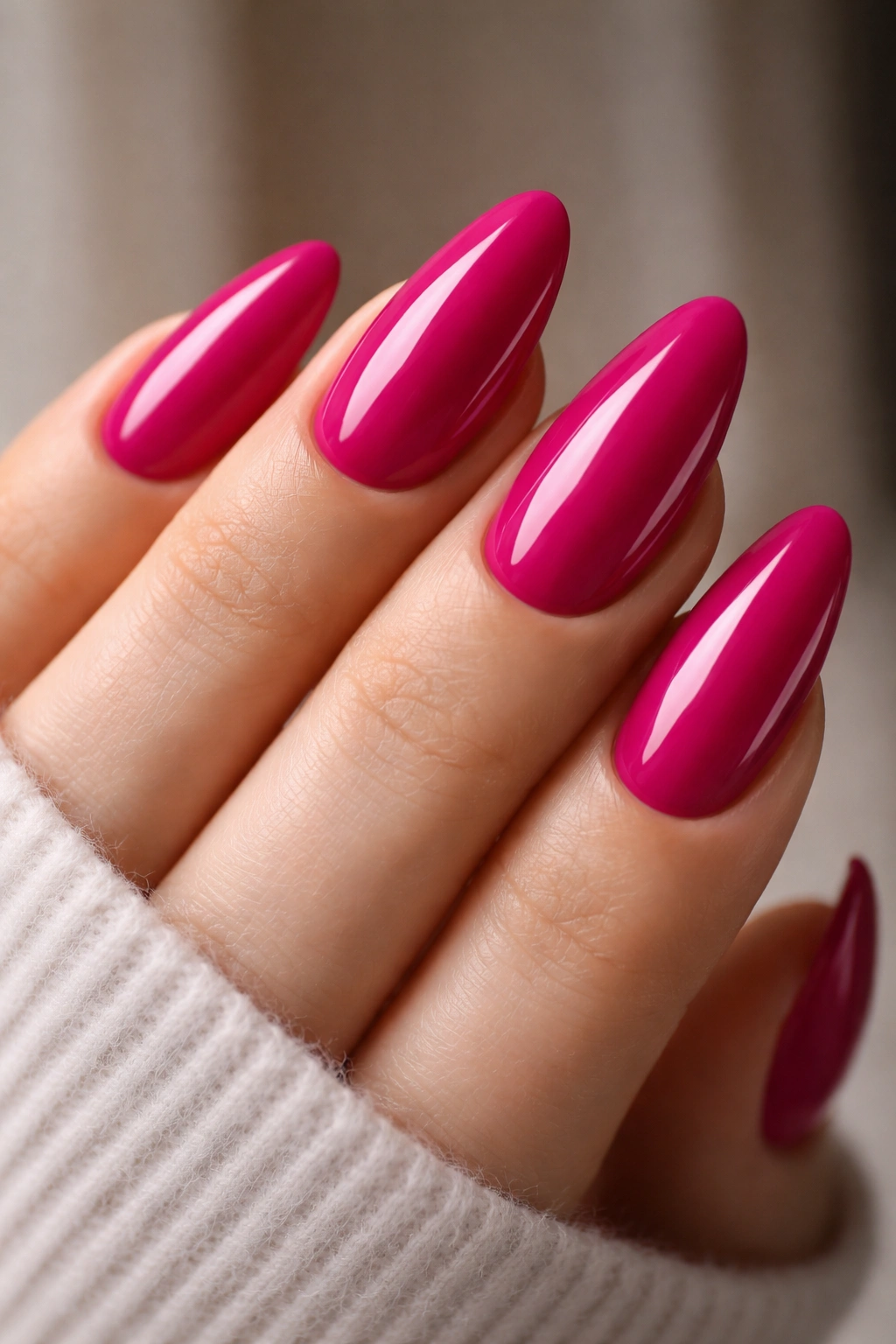 Close-up of magenta almond nails with saturated color and glossy finish