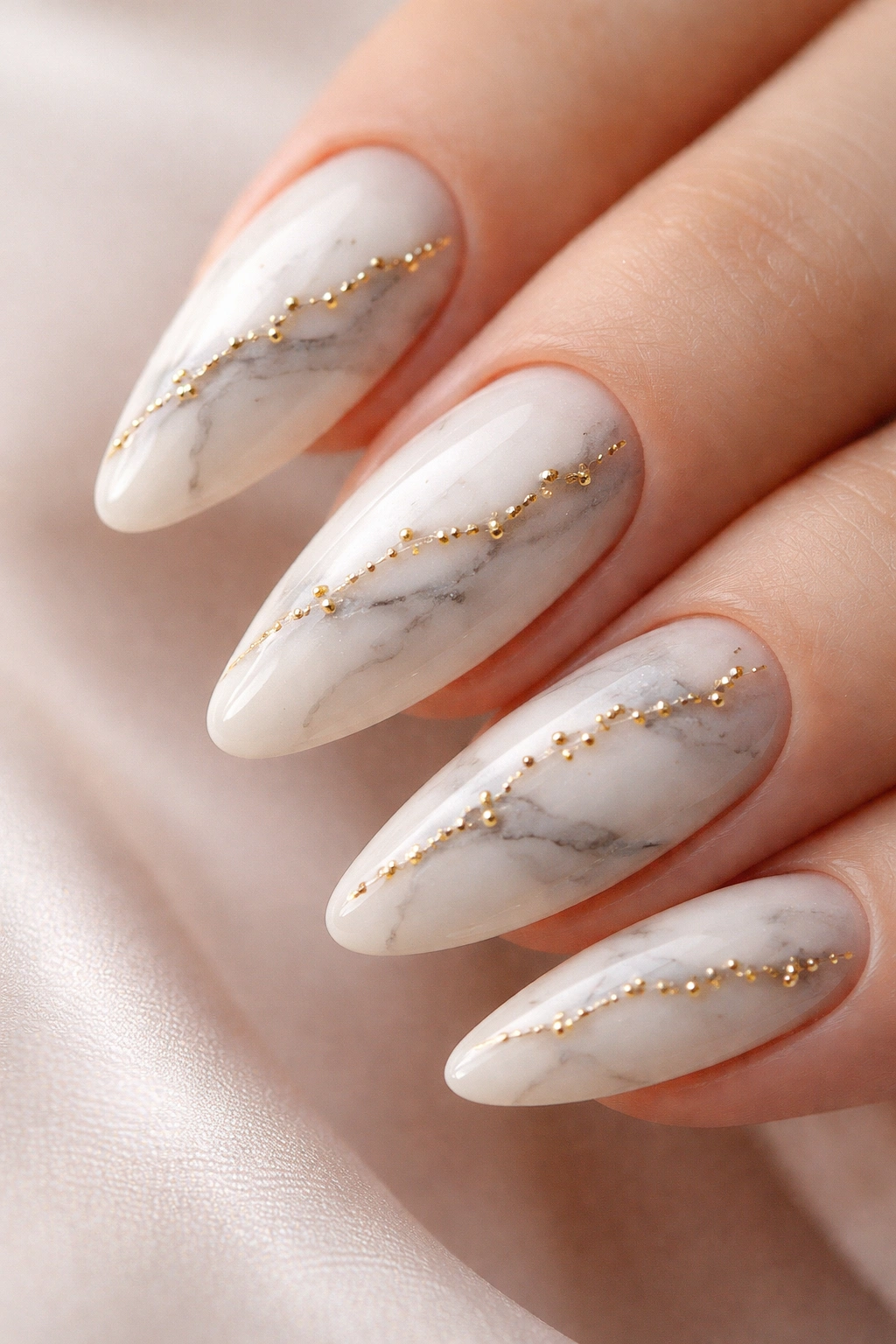 Almond nails marble texture with gold bead accents along veins