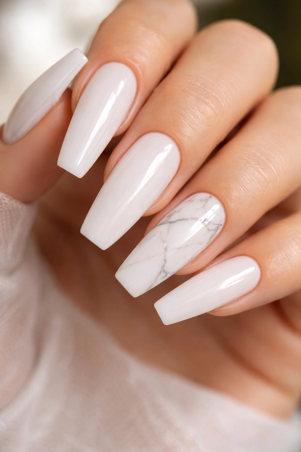 Close-up of white quartz marble nails with subtle gray veining on a milky base.