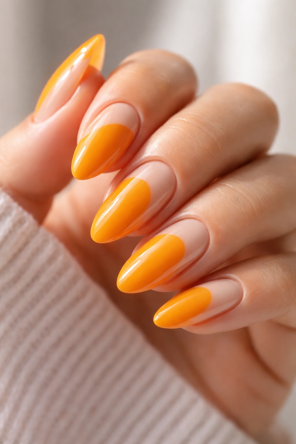 Almond nails with marigold orange and deliberate negative space