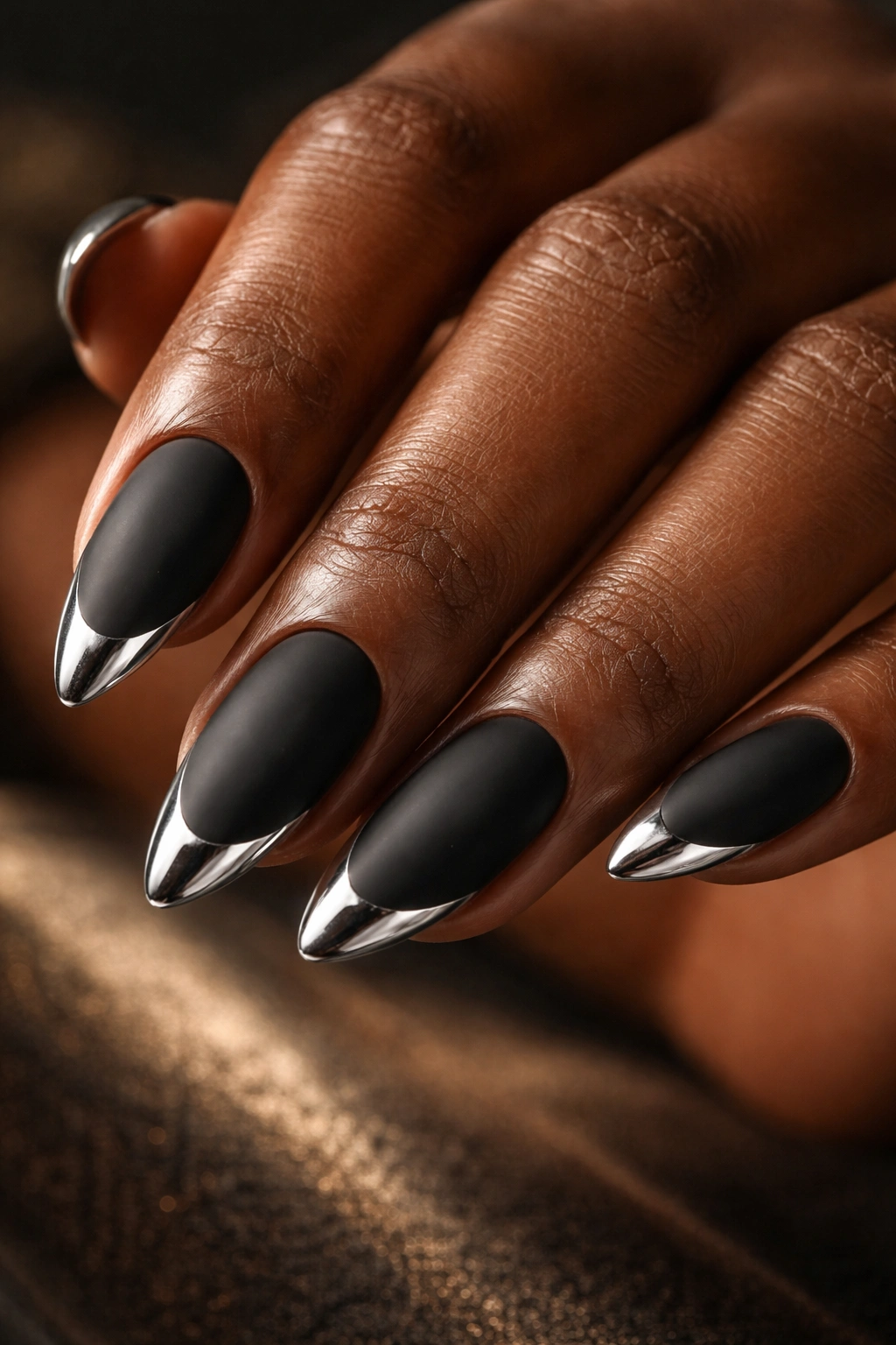 Matte black nails with chrome tips on almond shape