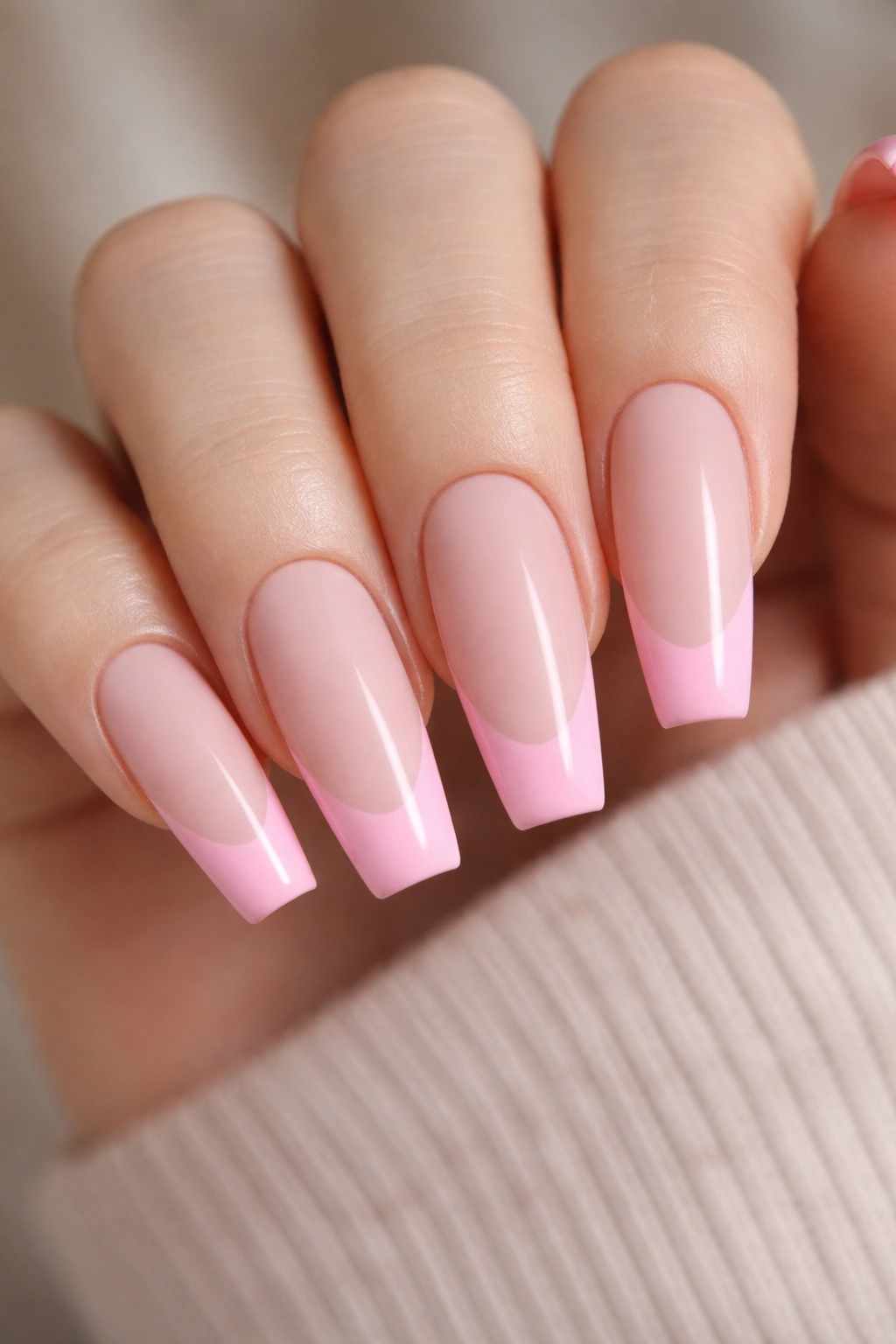 Close-up of coffin nails with matte blush base and glossy pink tips