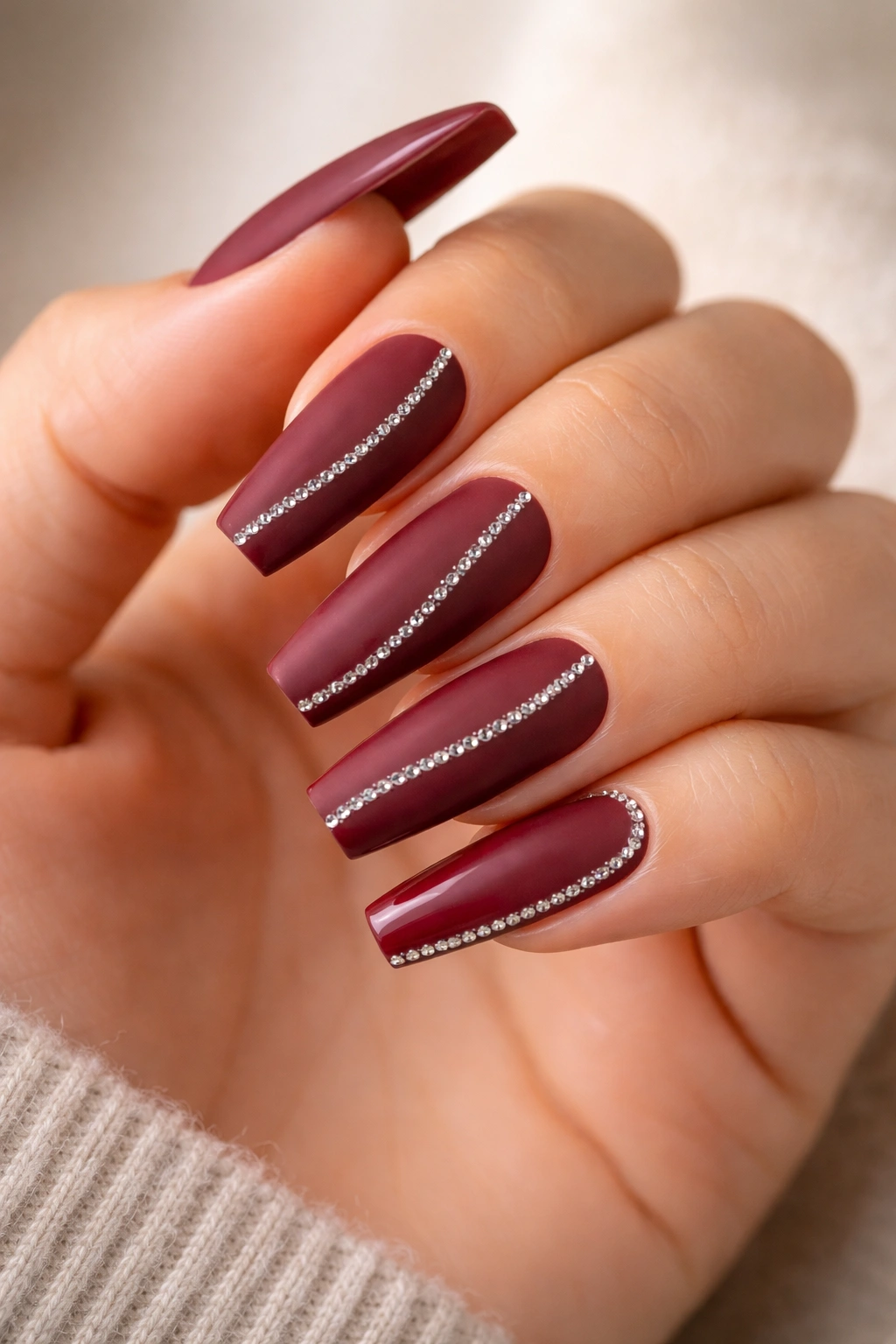Matte burgundy coffin nails with a single glossy gem line