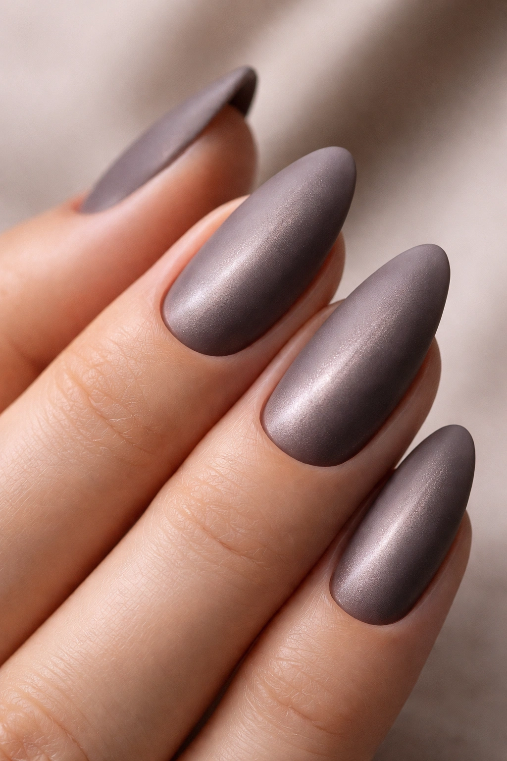 Close up of an almond nail with a matte cat eye finish and buried shimmer