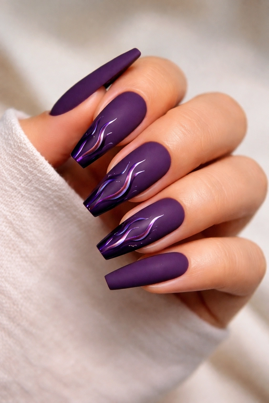Hand with matte grape coffin nails featuring glossy flame accents