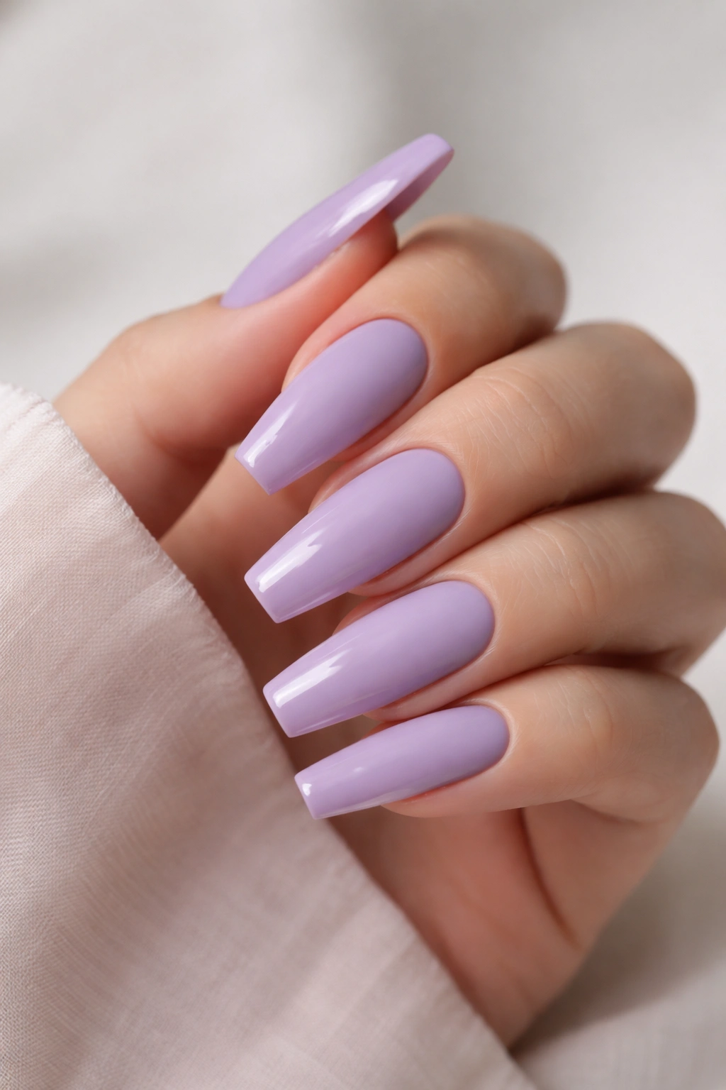 Close-up of matte lilac coffin nails with glossy tips.