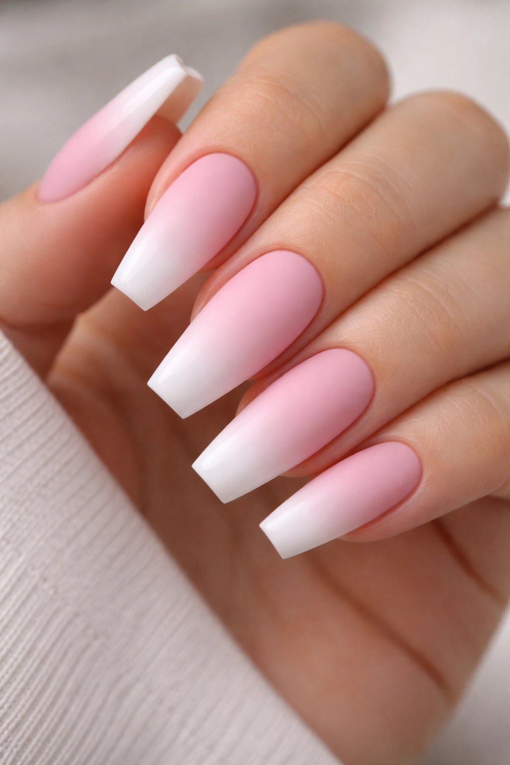 Close-up of matte pink and white ombre coffin nails with sharp sidewalls