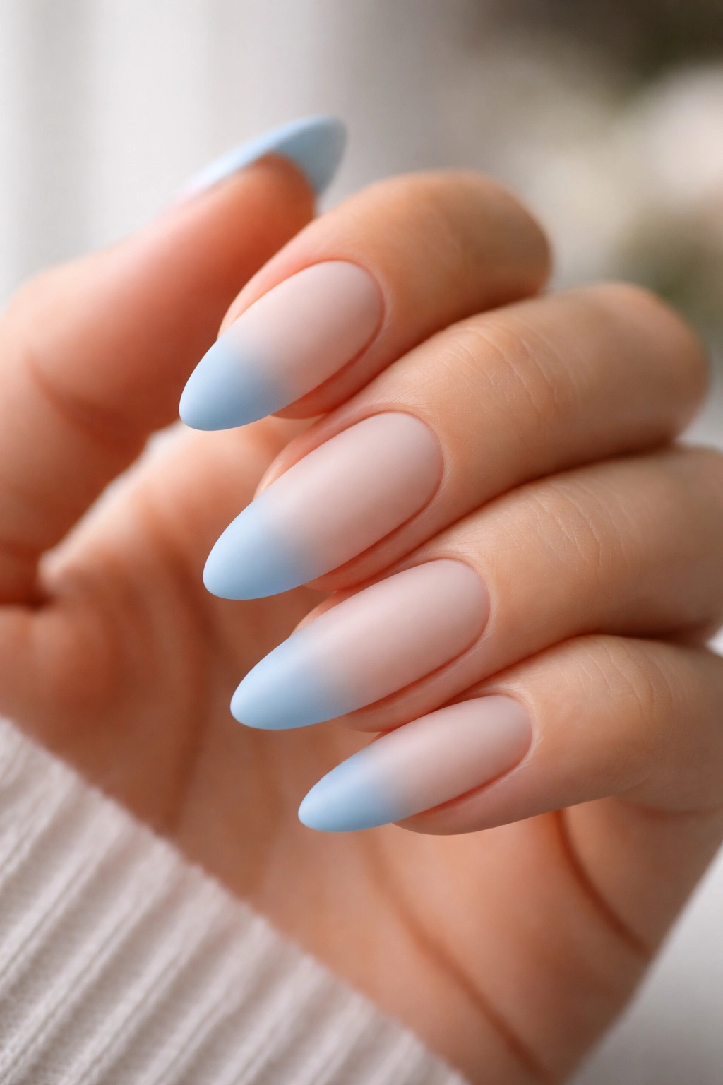 Almond nails with matte powder blue tips on milky base
